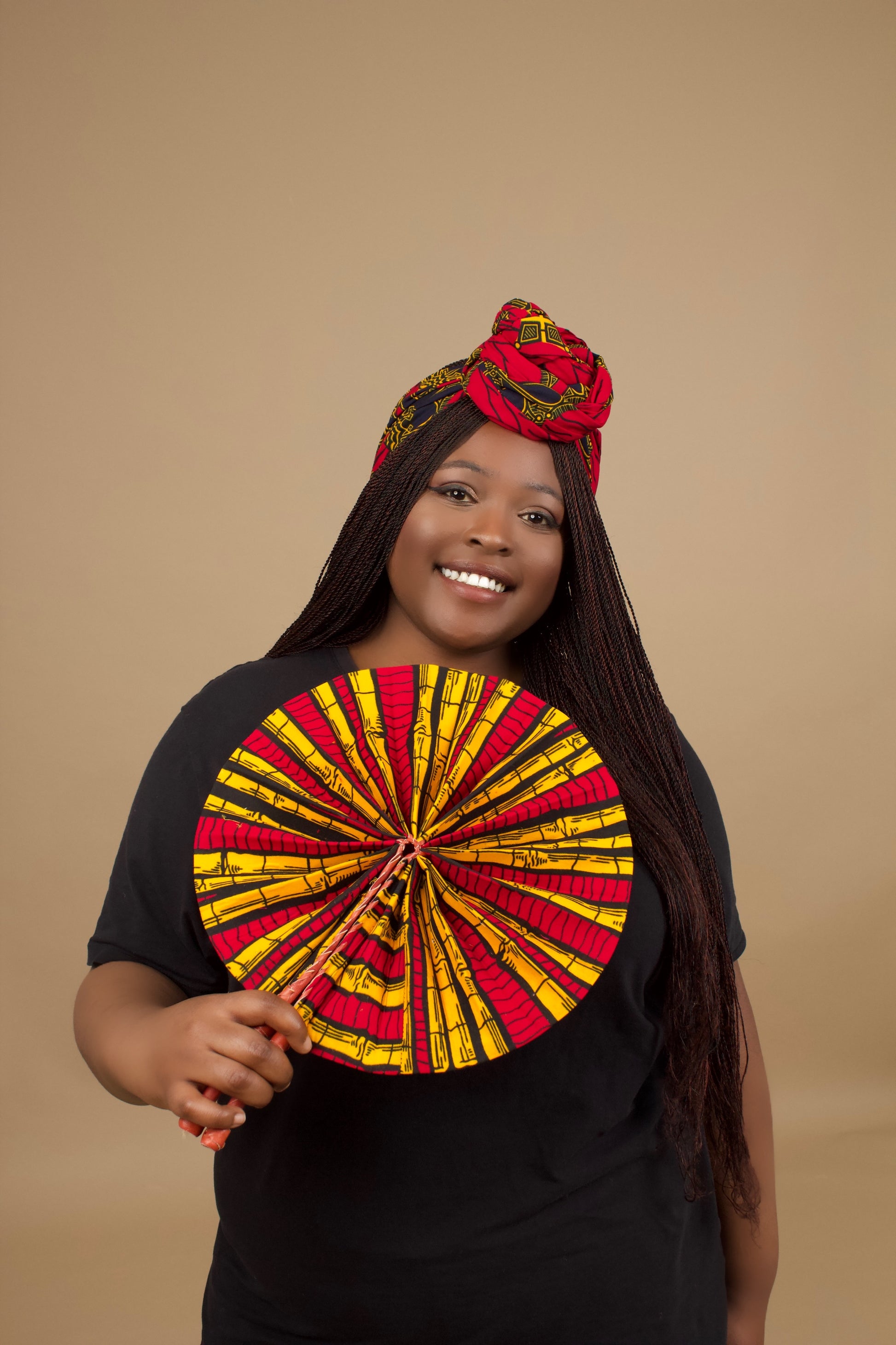 The expandable one-sized Keji i is African Print Reversible Fan is made from sustainably sourced 100% cotton Ankara wax print . It features a bold multi-colored bamboo tribal print in red, yellow and black  pattern and a Leather Handle and fastener. Designed and Made in Ghana.