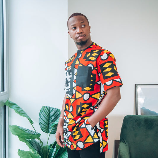 Black girl in a green and orange face mask against a leafy background