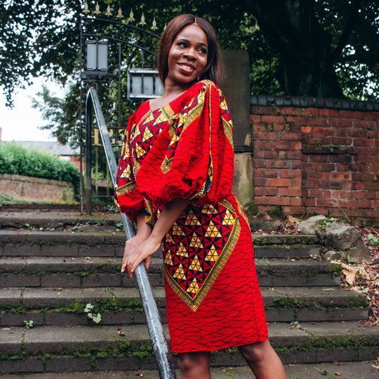 Ankara wax print African geo-shaped Triangle pattern in red, yellow and black on long three quarter ballooned sleeves, closed neckline, knee high body hugging pencil dress with belt feature.