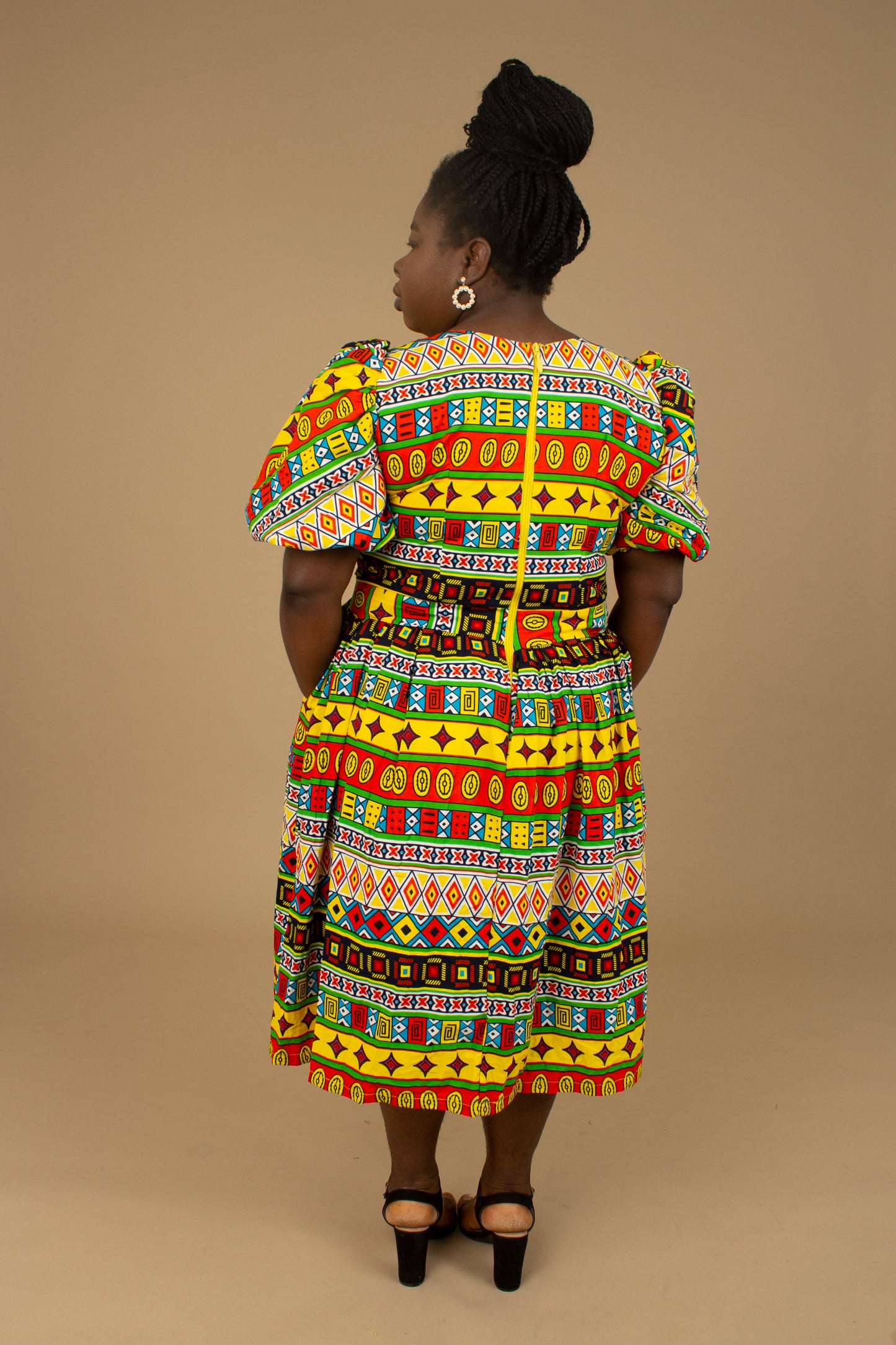 The Akala African Print Skater Dress is crafted from sustainable wax print and features two side pockets in a repeated multi-coloured geometric Kente pattern from cotton. Designed in England Made in Nigeria. Available in standard and plus sizes (UK 8-32).