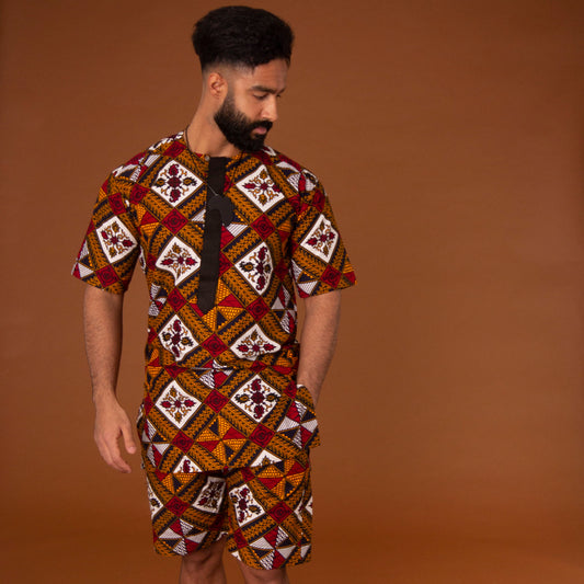African print kaftan top with black crepe trim and matching shorts with drawstring waist hand-made from red, yellow, white and black ankara wax print in a geometric pattern