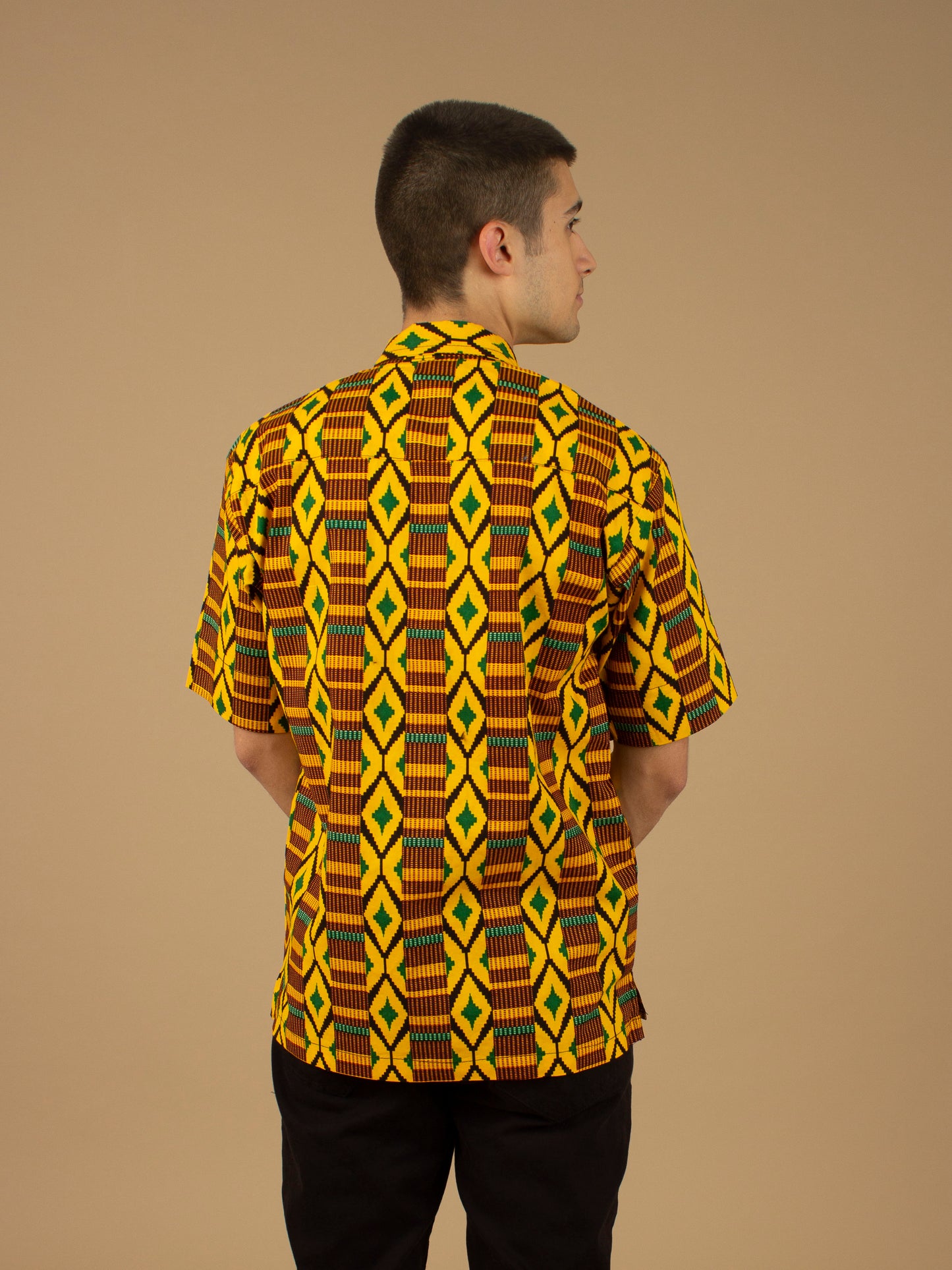 The Adina Kente African printed Button-Up shirt is a striking Diamond geometric kente pattern in green, yellow and black made from sustainably sourced 100% Cotton. Designed in England Made in Nigeria.