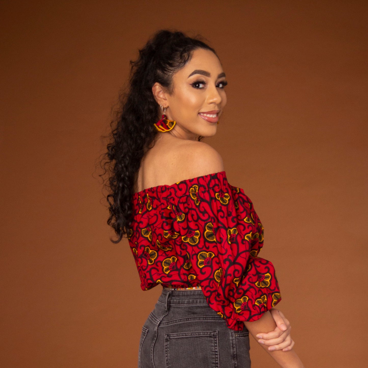 Off-shoulder African print crop top with three-quarter balloon sleeves and elasticated waist, arms and neckline in red and yellow ankara wax print