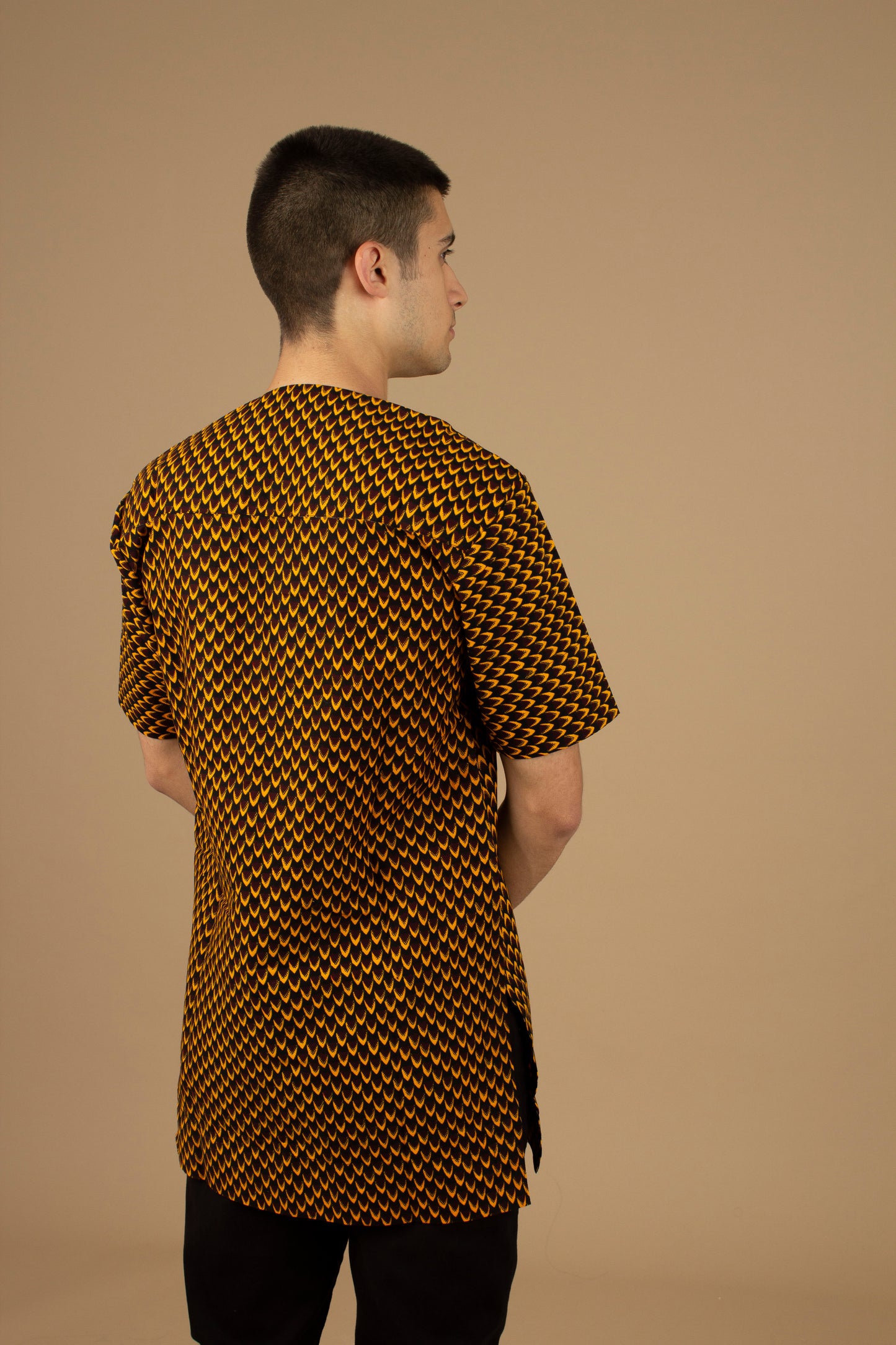 Vero African Print Kaftan Top is an ethically printed Matte Black Trimmed, Wax printed body style men's Kaftan top made from sustainably selected Cotton Ankara wax print in a repeated geometric brown and yellow African print pattern. Designed in England Made in Nigeria.