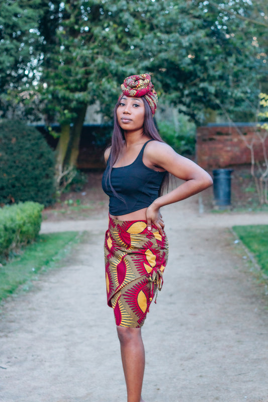 Red, yellow and brown African print head wrap tied a turban in graphic floral pattern, made from sustainably sourced Ankara wax print.
