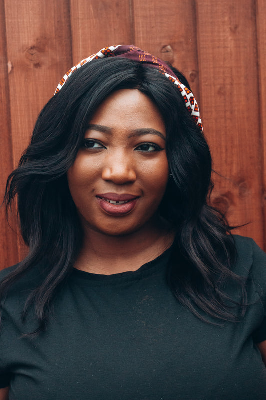 Brown, orange and white African print head wrap tied as headband in a titled squared brick pattern, made from sustainably sourced Ankara wax print.