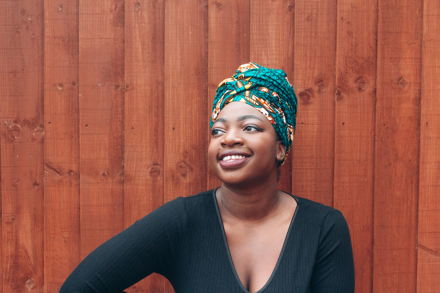 Orange, yellow, white and green African print head wrap tied a turban in a floral pattern, made from sustainably sourced Ankara wax print.