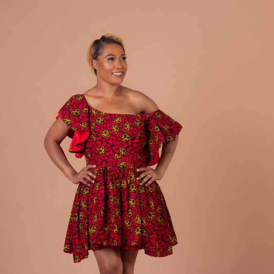 Red, yellow and black Ana African Ankara wax print in a floral pattern on a off the shoulder panelled ruffled skater dress with flared quarter sleeves with pockets on each side.