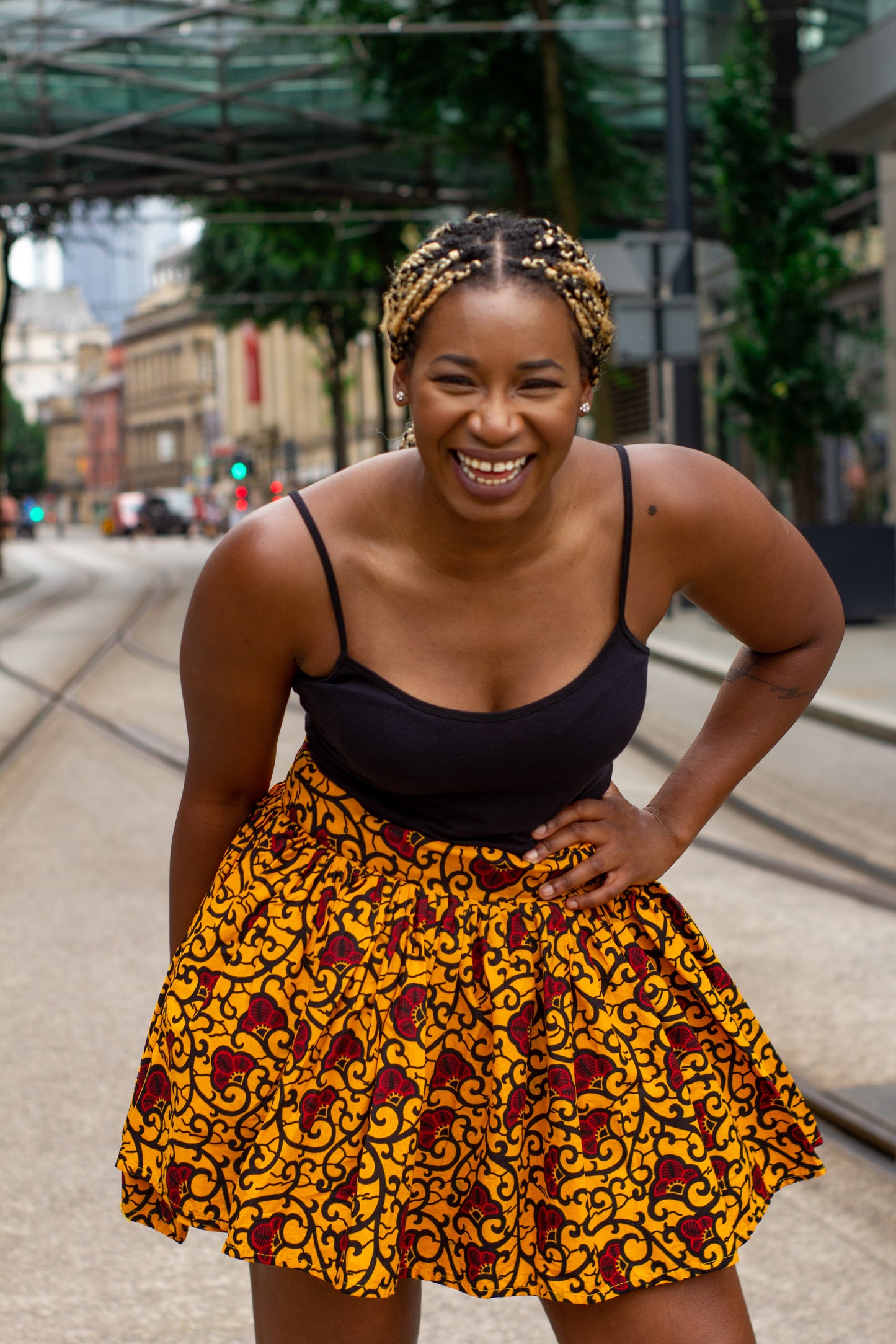 Yellow, red and black African print knee length pleated skater skirt in floral pattern, made from sustainably sourced Ankara wax print with belted seam detail.