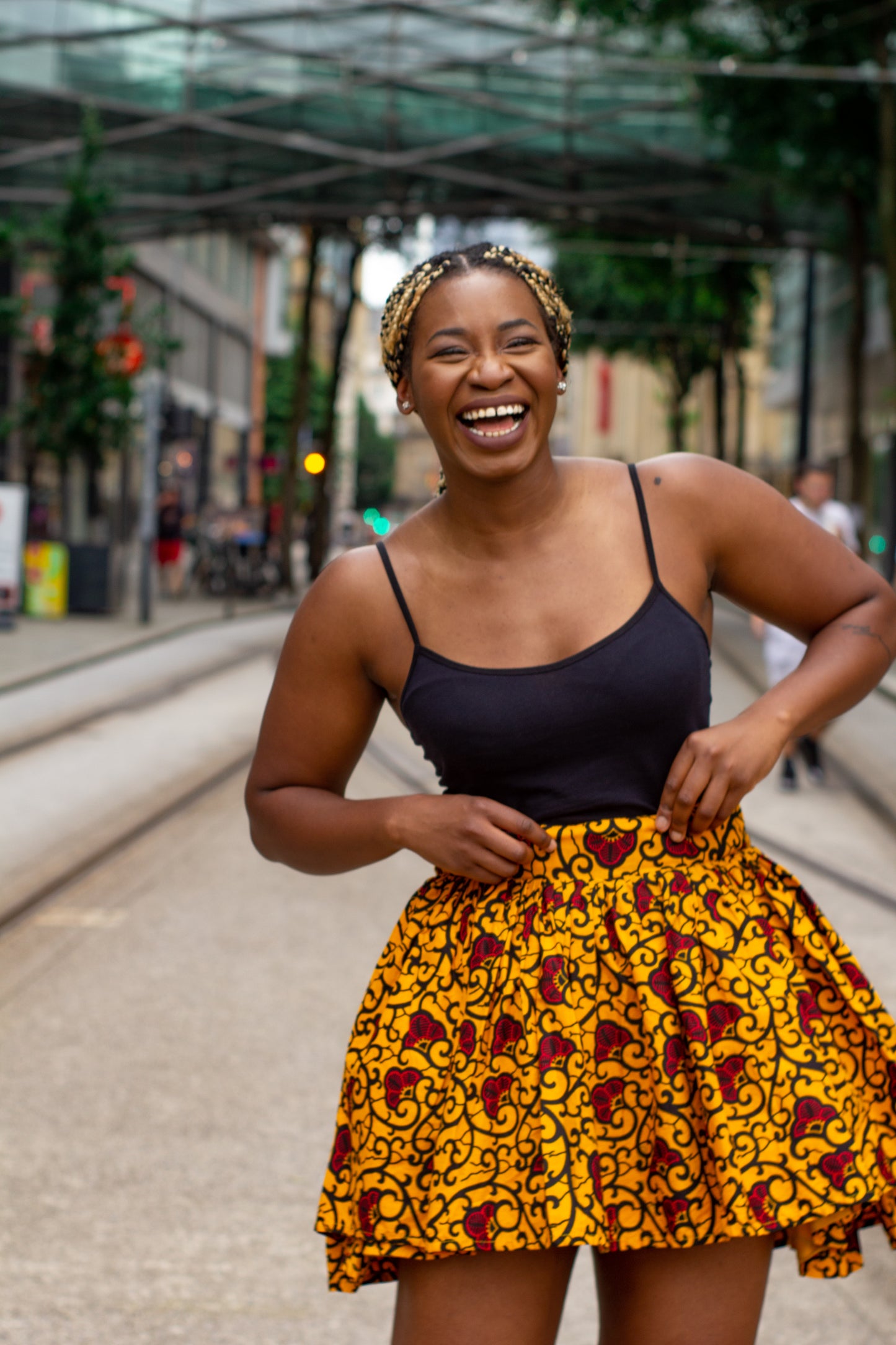 Yellow, red and black African print knee length pleated skater skirt in floral pattern, made from sustainably sourced Ankara wax print with belted seam detail.