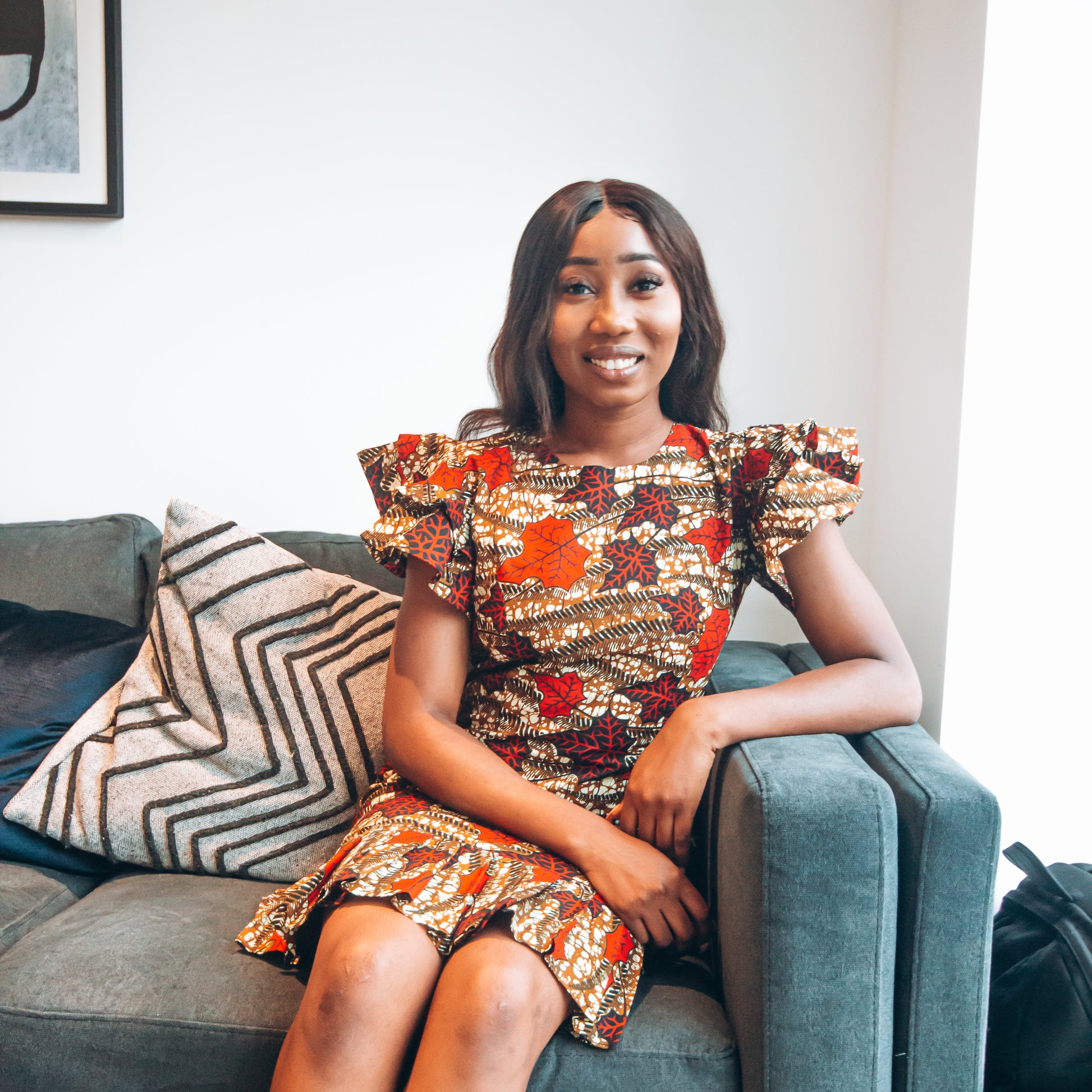 Brown, red, white, and black African Oti  floral textured leaf pattern below the Knee fishtailed, closed neckline body  hugging pencil dress with a fitted upper half with slightly flared quarter sleeves.