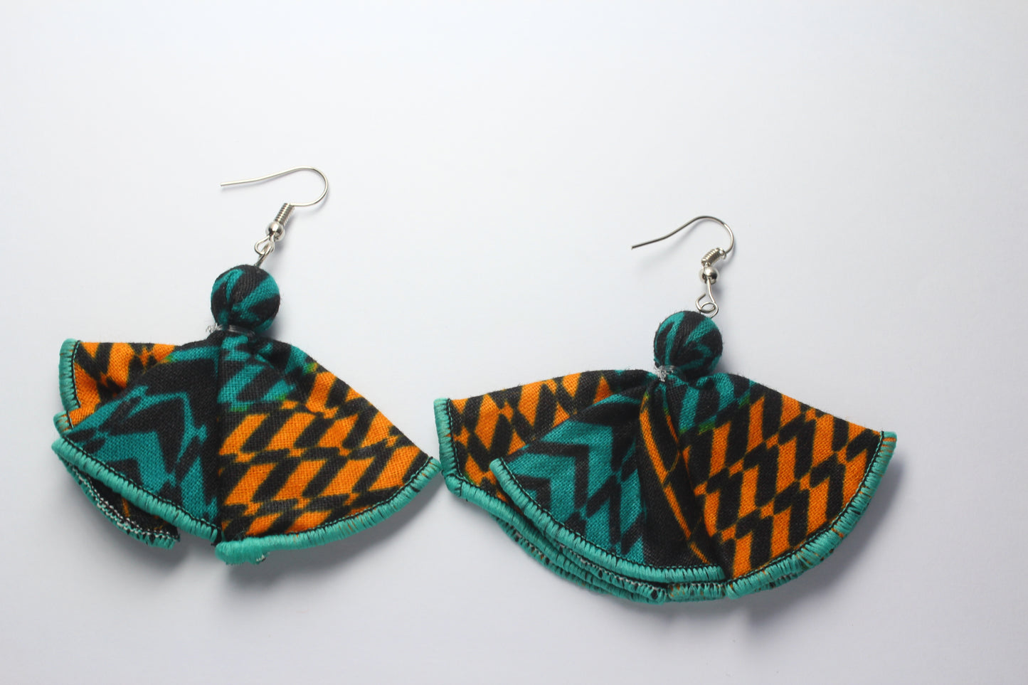African wax print geometric Adetayo fabric in green and orange butterfly embroidered earrings on a white background