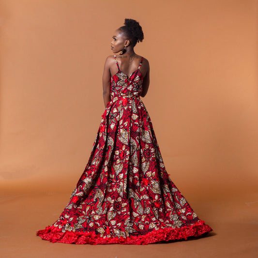 Ankara wax print in the bold African floral red, cream and light brown Ade fabric floor-length gown featuring a sweetheart neckline, closed back and off-shoulder straps with a matching outer cape belt.