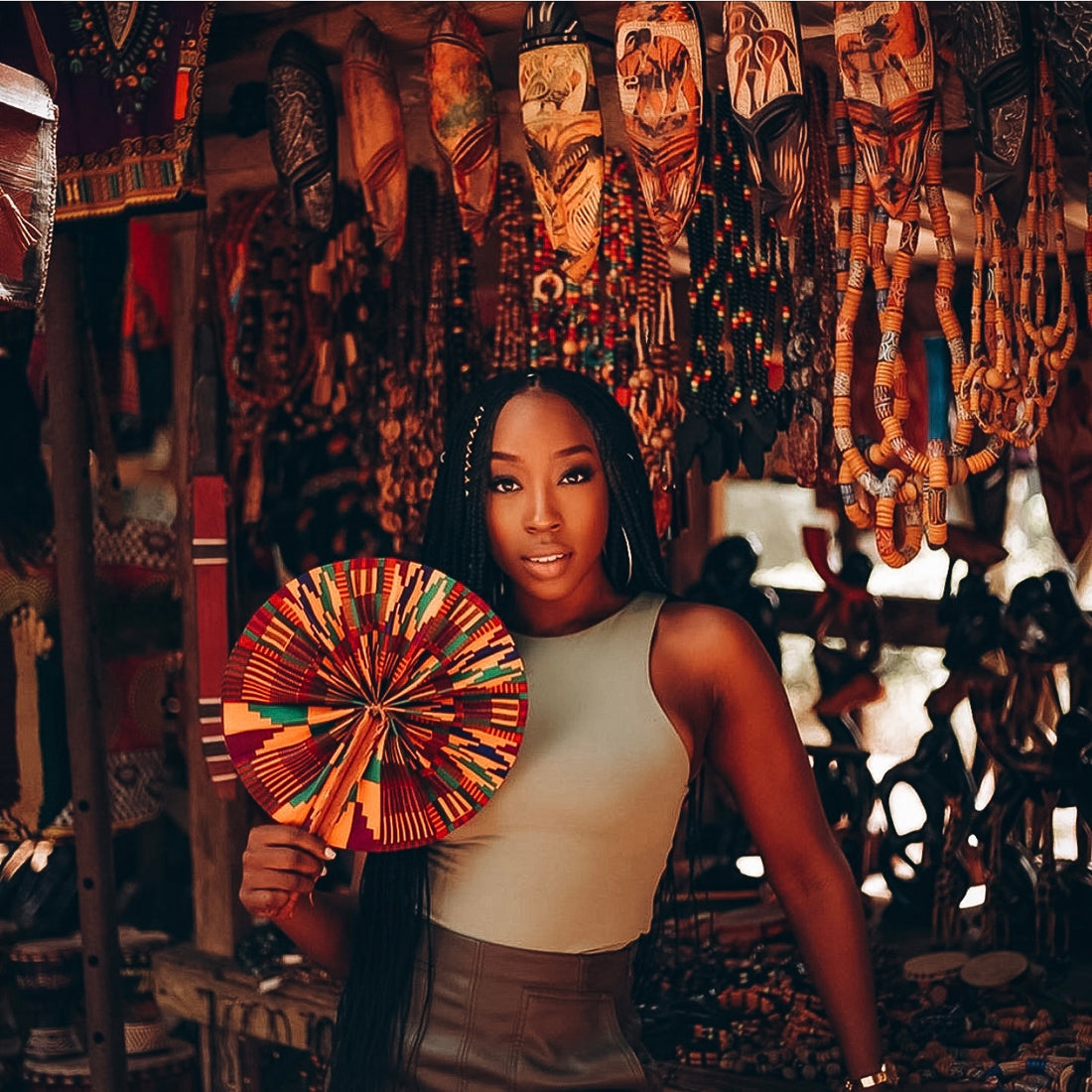 Black woman with multicouloured African print fan in an African store with African accessories