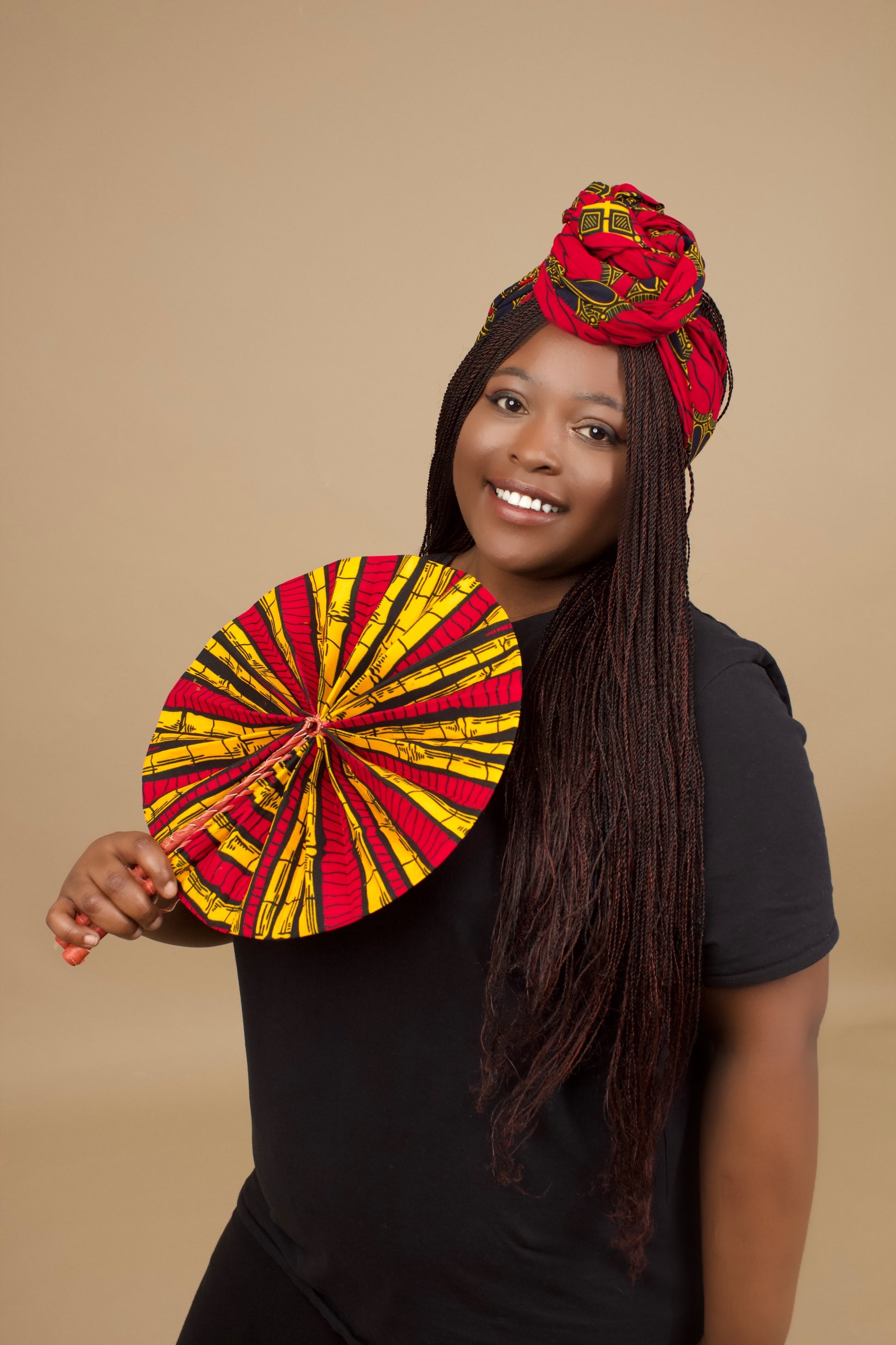 The expandable one-sized Keji i is African Print Reversible Fan is made from sustainably sourced 100% cotton Ankara wax print . It features a bold multi-colored bamboo tribal print in red, yellow and black  pattern and a Leather Handle and fastener. Designed and Made in Ghana.
