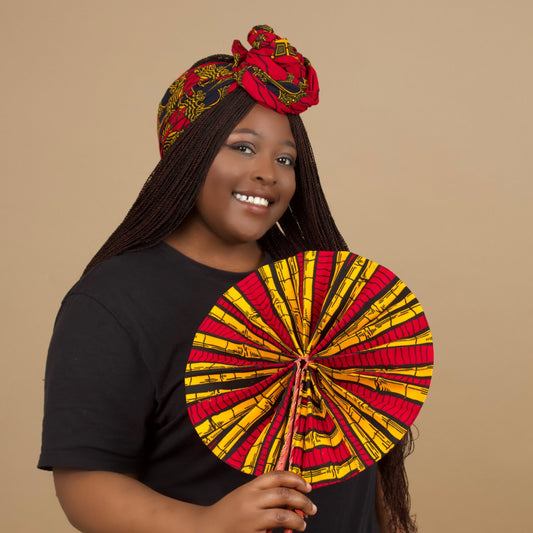 The expandable one-sized Keji i is African Print Reversible Fan is made from sustainably sourced 100% cotton Ankara wax print . It features a bold multi-colored bamboo tribal print in red, yellow and black  pattern and a Leather Handle and fastener. Designed and Made in Ghana.