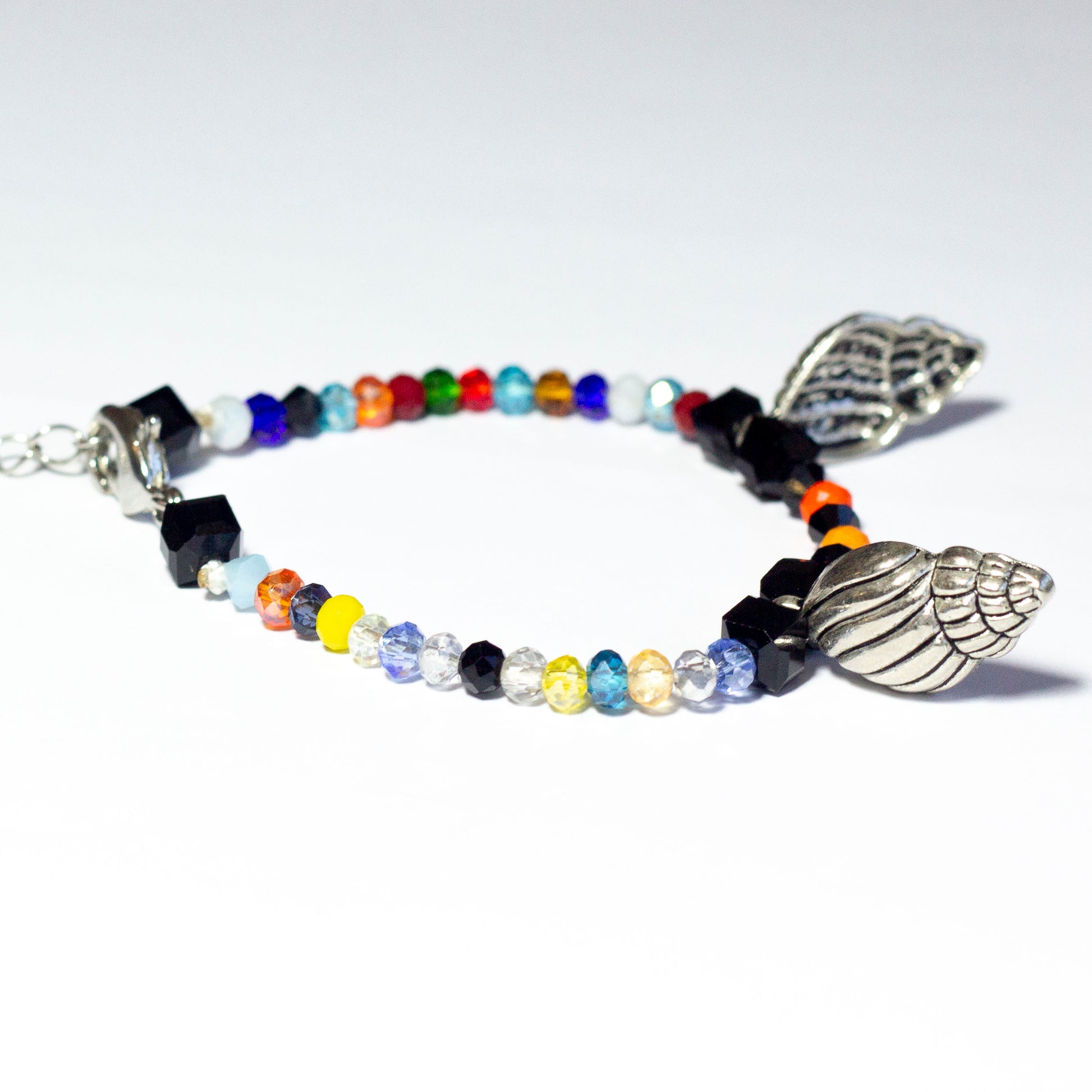 Multicoloured beaded bracelet made of crystal beads featuring metallic seashell pendants and a chain clasp design
