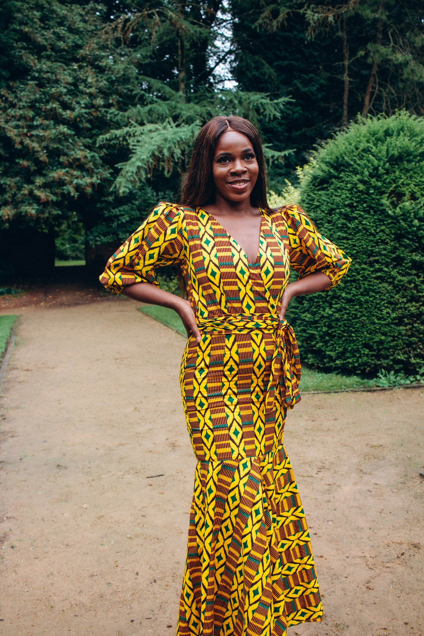 Floor length V-neck wrapped, fishtail dress featuring balloon sleeves and belt in yellow , brown, green and black Kente African Ankara wax printed Fabric.