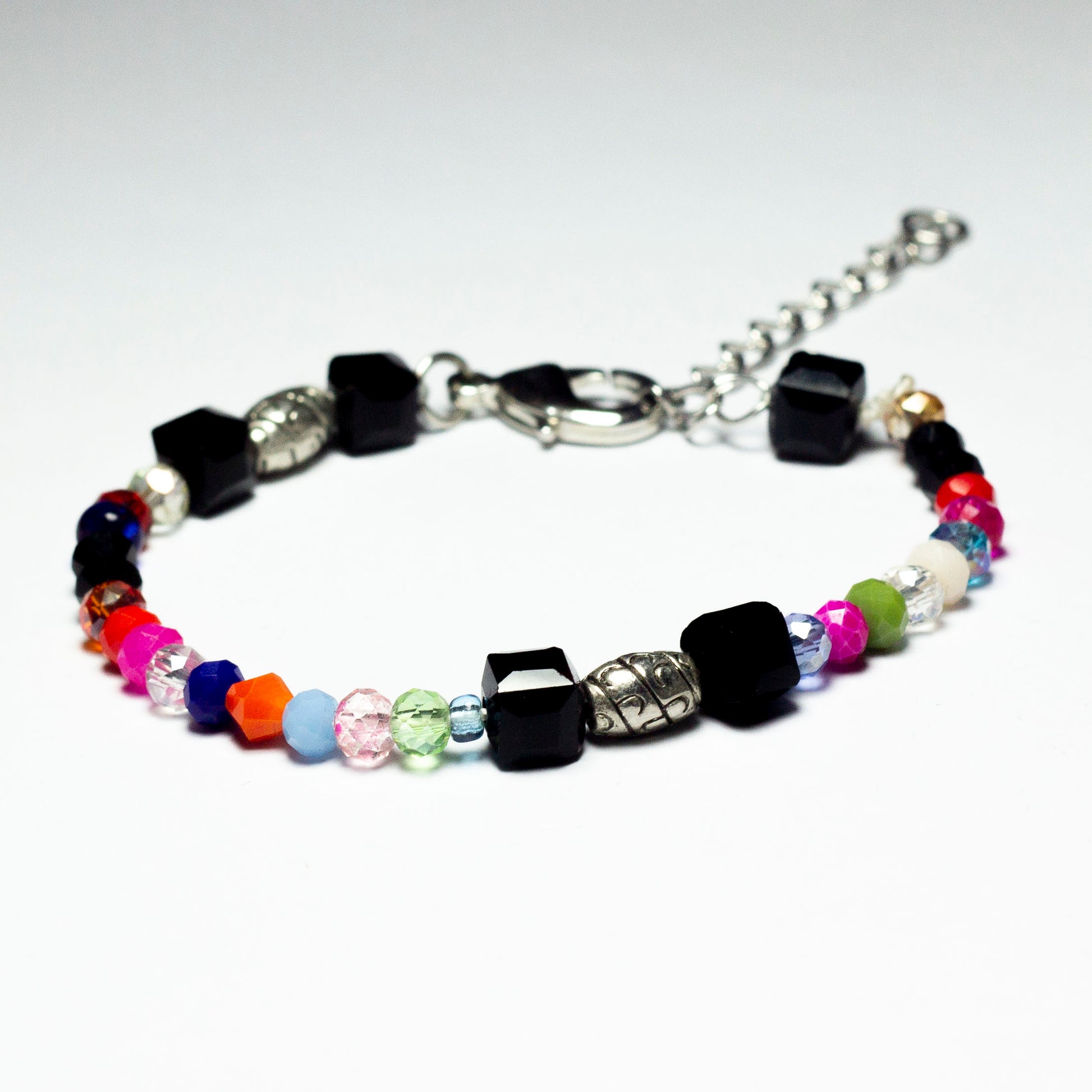Multicoloured beaded bracelet made of crystal beads featuring engraved cylinder pendants and a chain clasp design