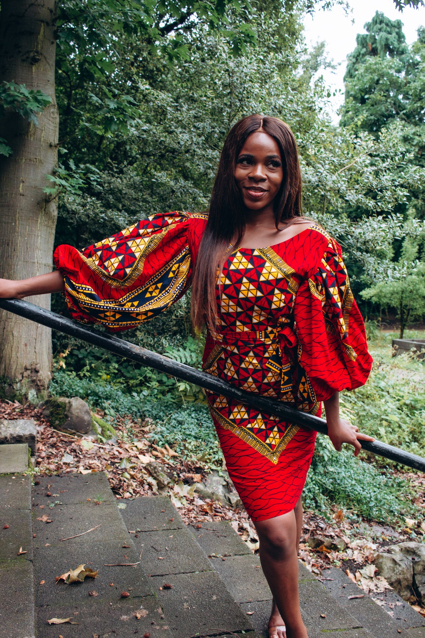 Ankara wax print African geo-shaped Triangle  pattern in red, yellow and black on long  three quarter ballooned sleeves, closed neckline, knee high body hugging pencil dress with belt feature.