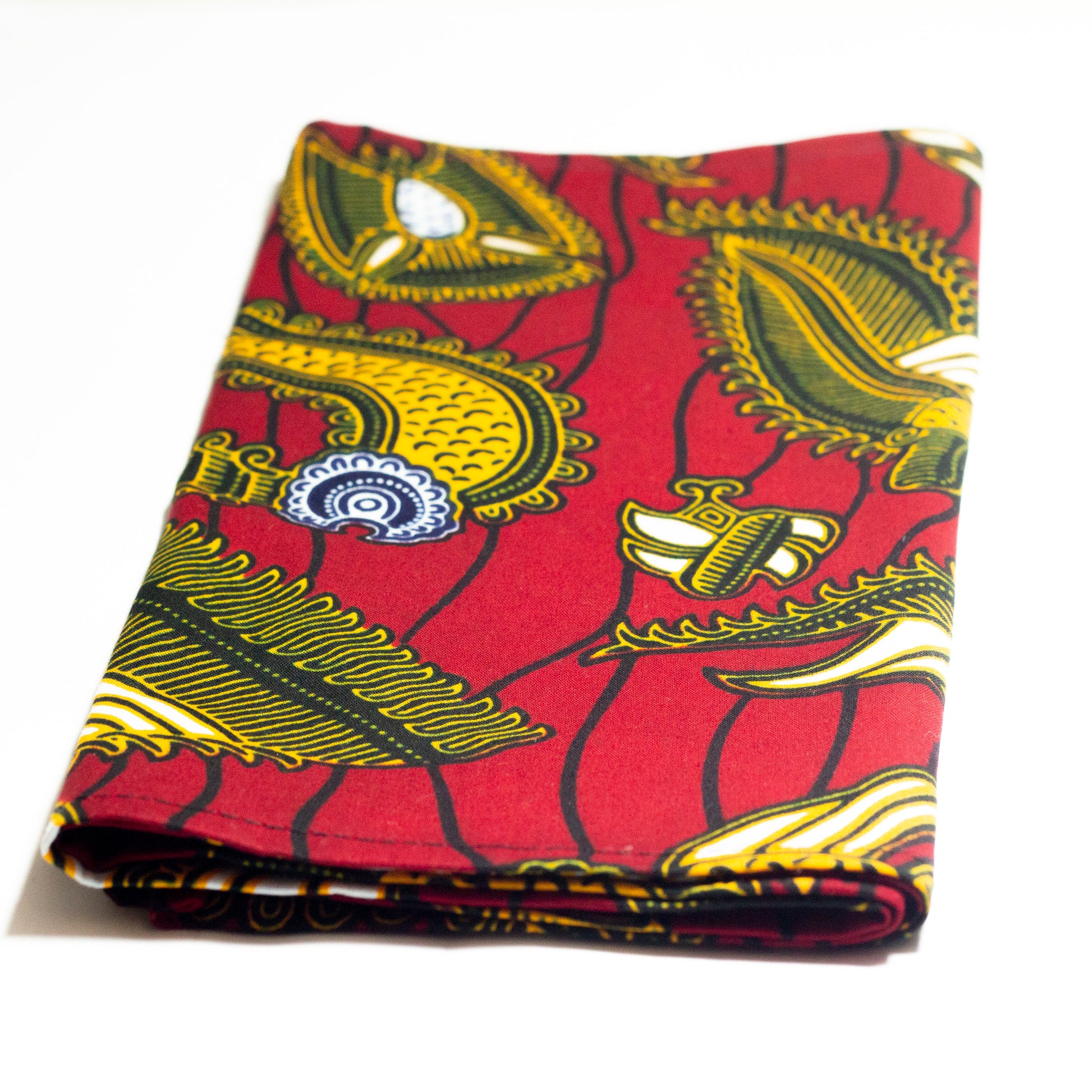 Red, yellow white and black African print head wrap fabric in a floral medallion pattern, made from sustainably sourced Ankara wax print.