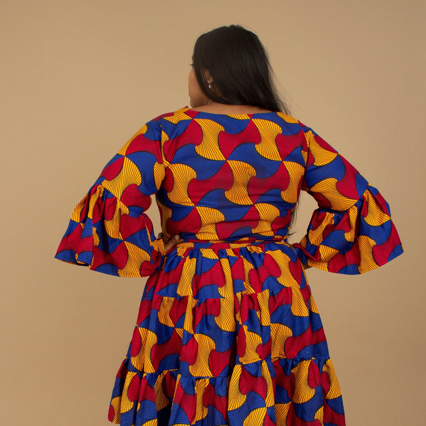 The Kano African Printed ruffled dress features an Ankara wax Print Belted Trim in a gorgeous blue, red and yellow multi-colored swirling geometric African Print pattern on sustainable cotton. Designed in England Made in Nigeria, Available in standard and plus sizes (UK 8-32). 