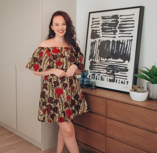  Brown, red, white, and black African Oti  floral textured leaf pattern on Knee length high-low dreads off the shoulder skater dress with slightly flared quarter sleeves, featuring Pockets on each side.