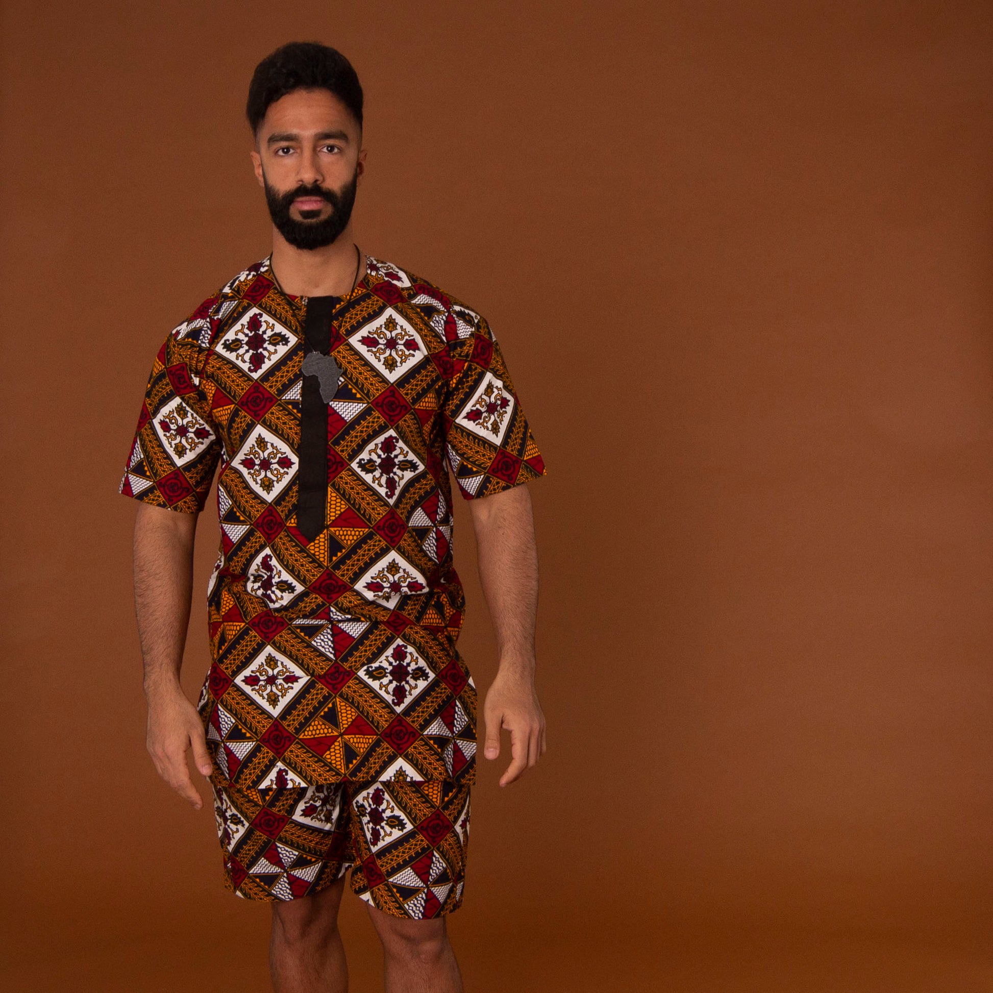 African print kaftan top with black crepe trim on the neckline hand-made from red, yellow, white and black ankara wax print in a geometric pattern