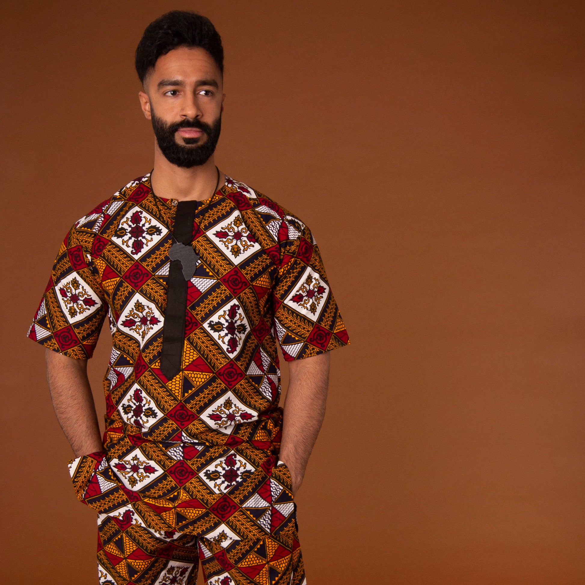 African print kaftan top with black crepe trim on the neckline hand-made from red, yellow, white and black ankara wax print in a geometric pattern