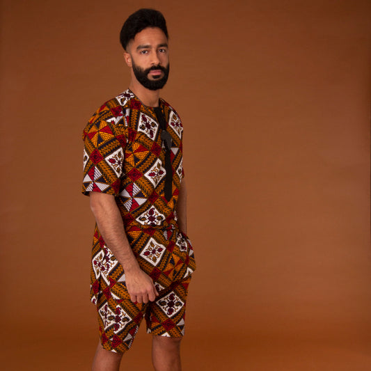 African print kaftan top with black crepe trim and matching shorts with drawstring waist hand-made from red, yellow, white and black ankara wax print in a geometric pattern