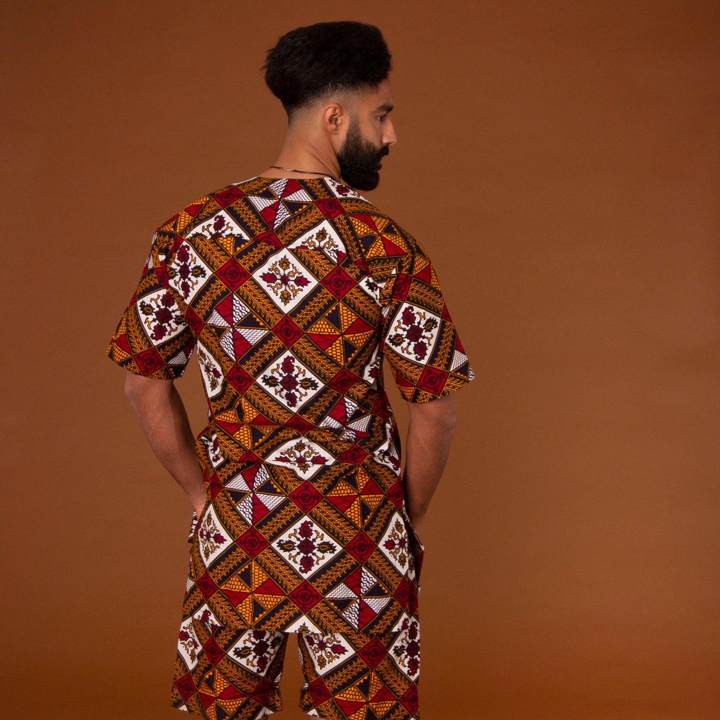 African print kaftan top with black crepe trim on the neckline hand-made from red, yellow, white and black ankara wax print in a geometric pattern