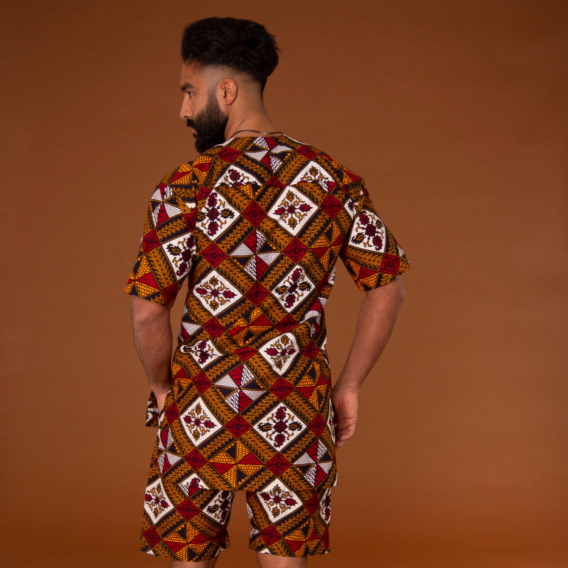 African print kaftan top with black crepe trim and matching shorts with drawstring waist hand-made from red, yellow, white and black ankara wax print in a geometric pattern