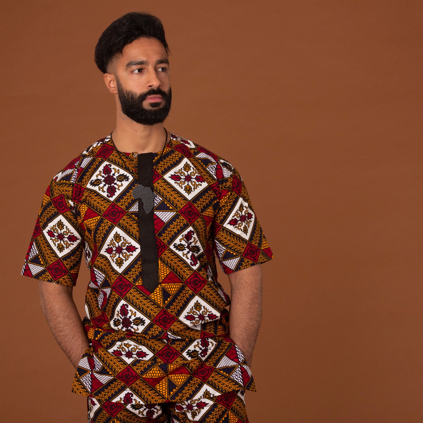 African print kaftan top with black crepe trim on the neckline hand-made from red, yellow, white and black ankara wax print in a geometric pattern