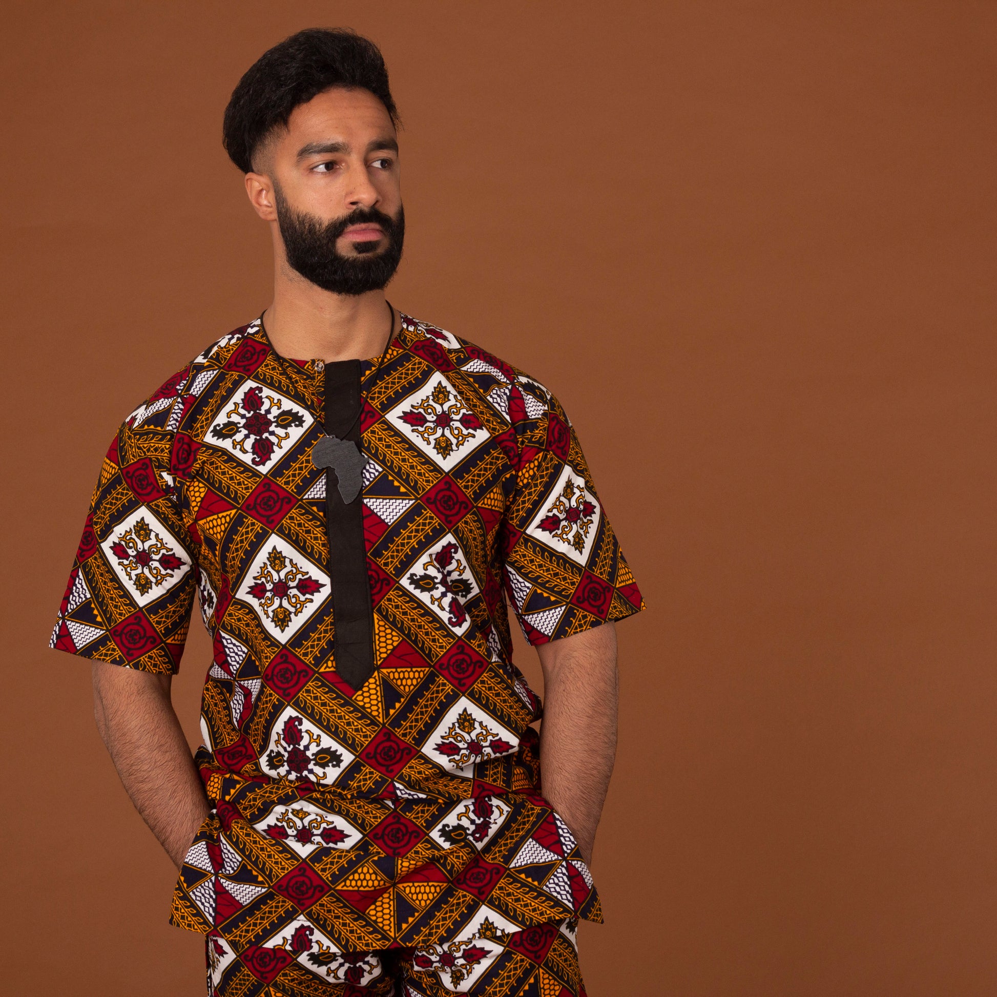 African print kaftan top with black crepe trim on the neckline hand-made from red, yellow, white and black ankara wax print in a geometric pattern