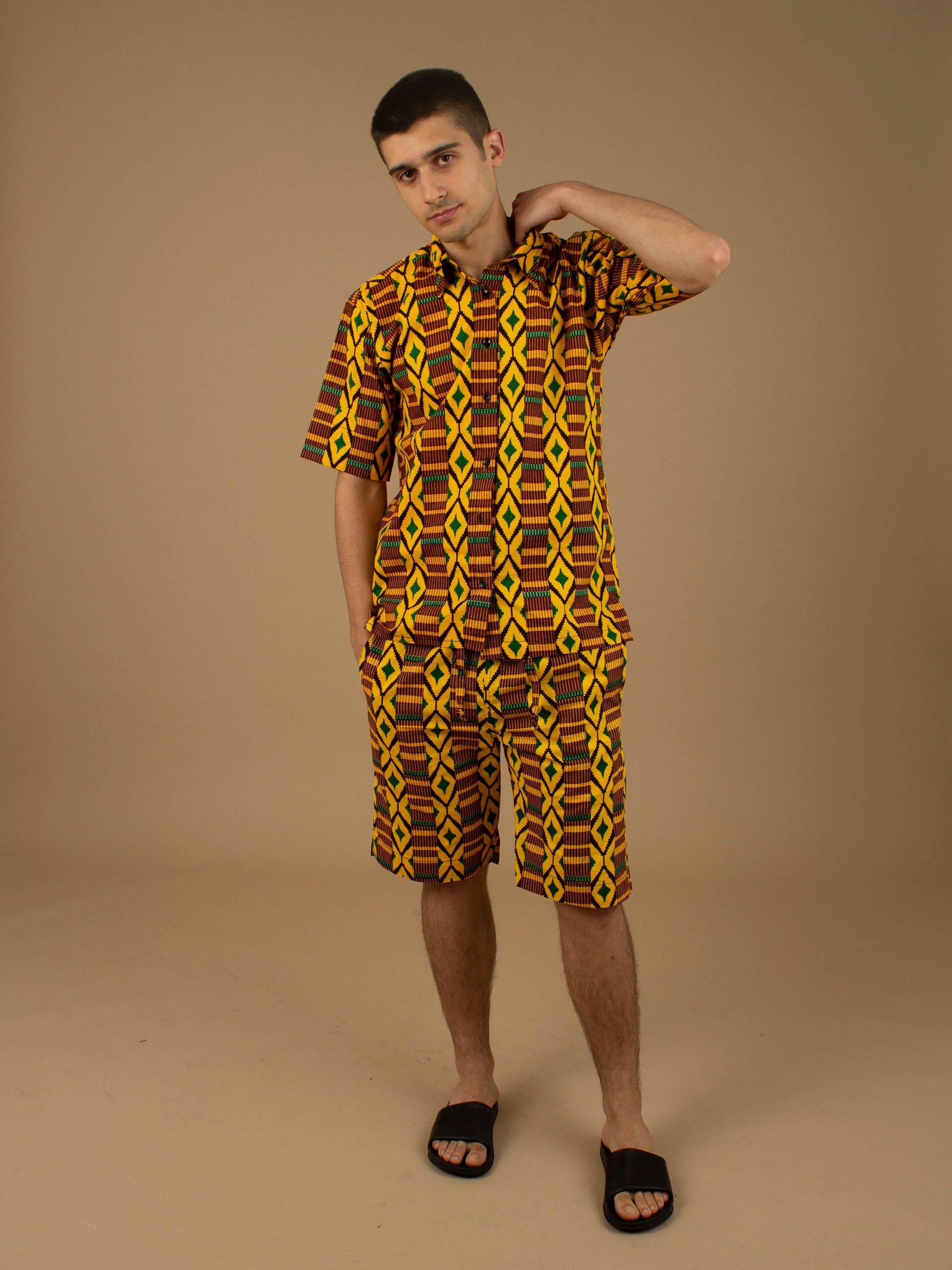 The Adina Kente African Print two- piece Button-Up shirt and Shorts in a striking Diamond geometric kente pattern in  green, yellow and black made from sustainably sourced 100% Cotton. Designed in England Made in Nigeria.
