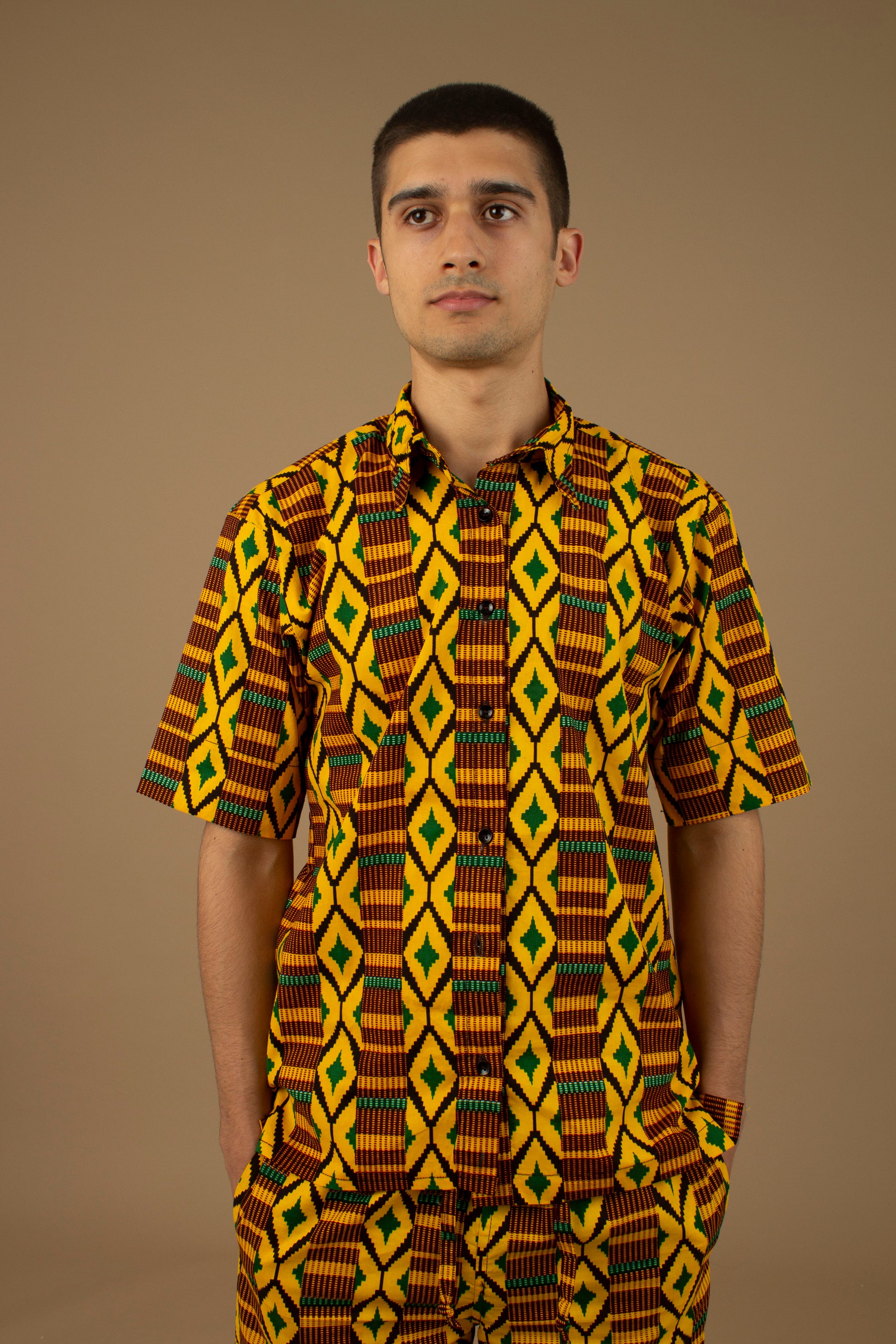 The Adina Kente African Print two- piece Button-Up shirt and Shorts in a striking Diamond geometric kente pattern in  green, yellow and black made from sustainably sourced 100% Cotton. Designed in England Made in Nigeria.