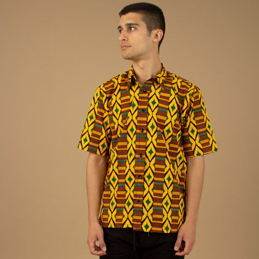 The Adina Kente African printed Button-Up shirt is a striking Diamond geometric kente pattern in  green, yellow and black made from sustainably sourced 100% Cotton. Designed in England Made in Nigeria.