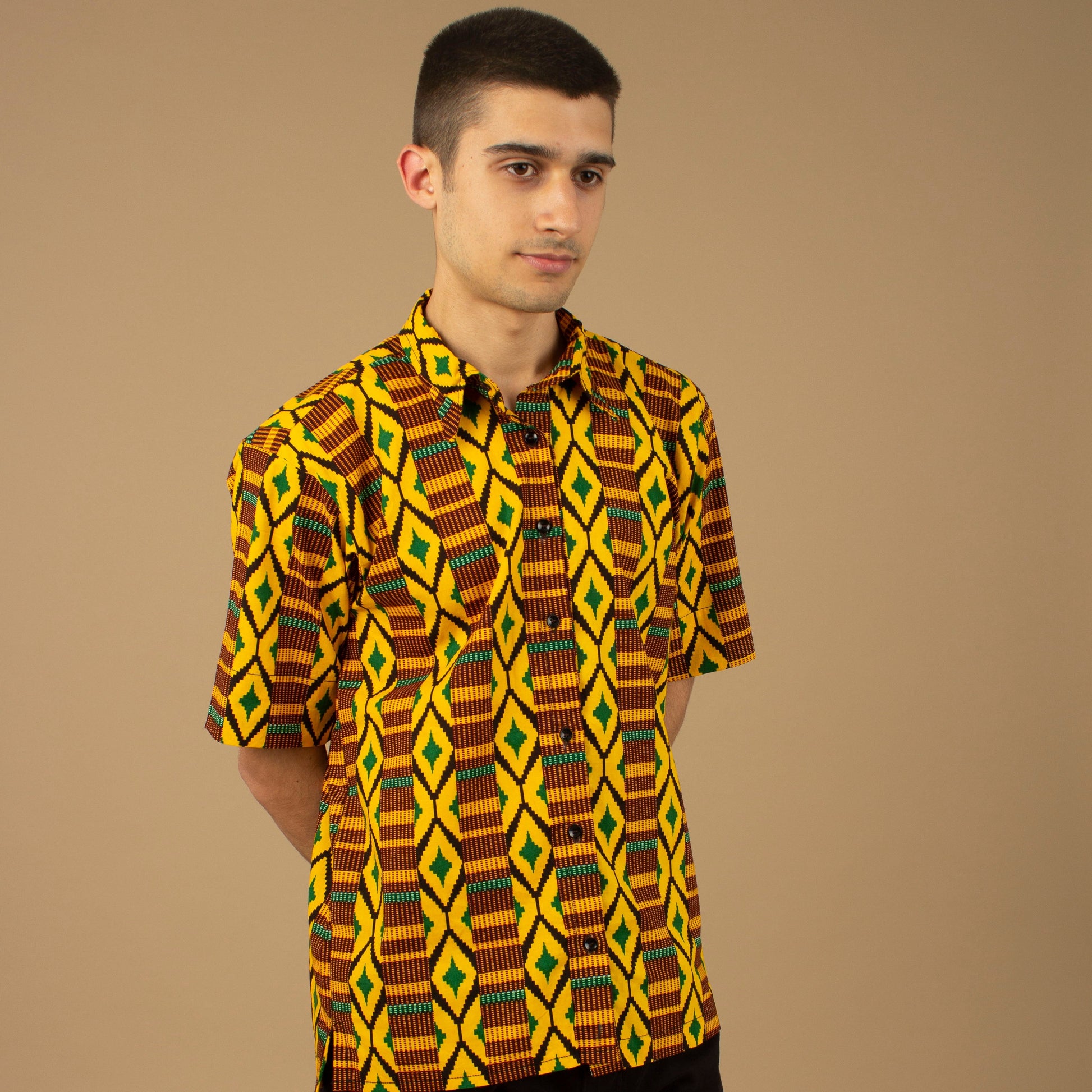 The Adina Kente African printed Button-Up shirt is a striking Diamond geometric kente pattern in  green, yellow and black made from sustainably sourced 100% Cotton. Designed in England Made in Nigeria.