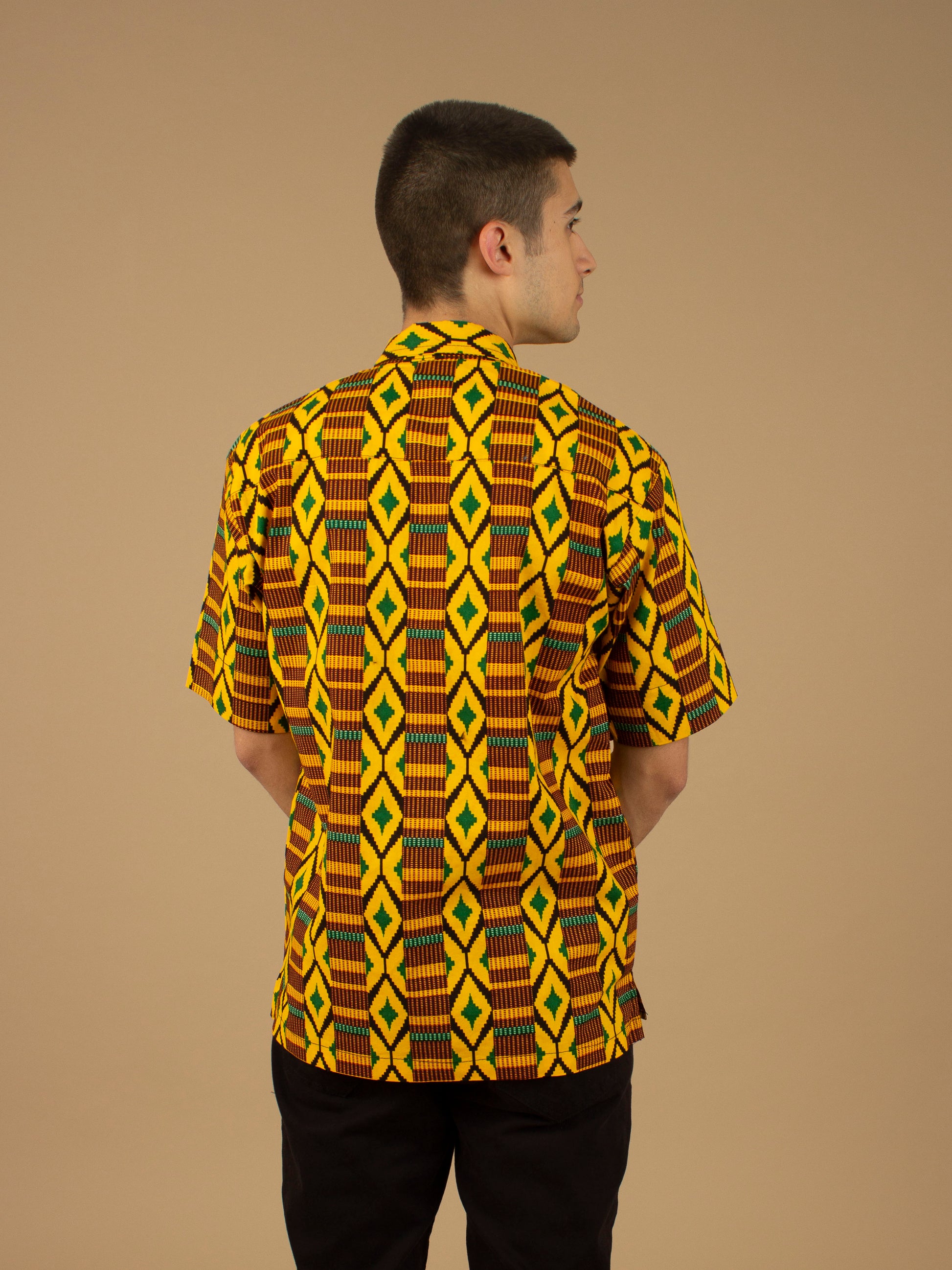 The Adina Kente African printed Button-Up shirt is a striking Diamond geometric kente pattern in  green, yellow and black made from sustainably sourced 100% Cotton. Designed in England Made in Nigeria.
