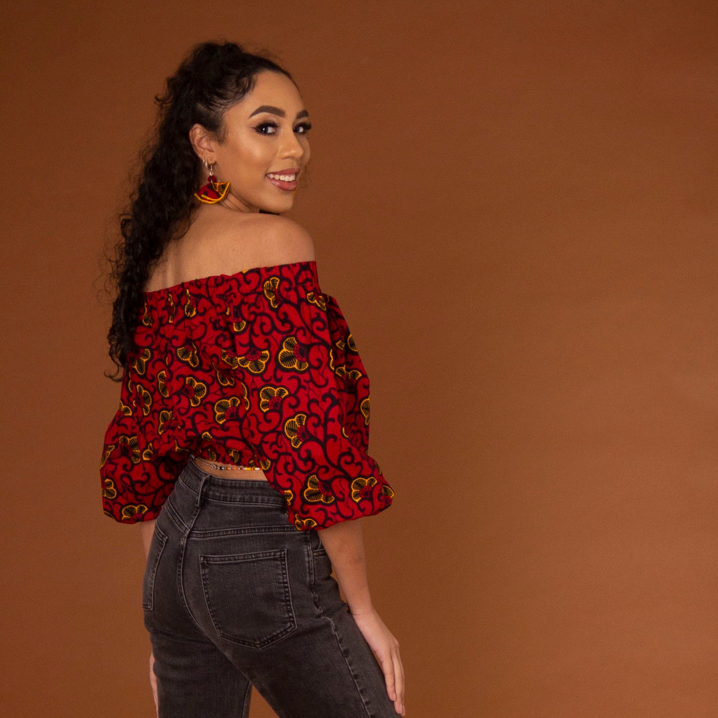 Off-shoulder African print crop top with three-quarter balloon sleeves and elasticated waist, arms and neckline in red and yellow ankara wax print