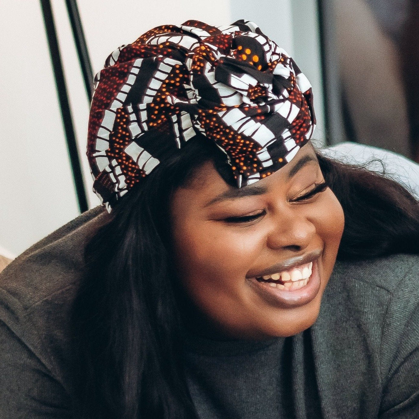 Brown, orange, white and black African print head wrap fabric in a graphic floral pattern, made from sustainably sourced Ankara wax print.
