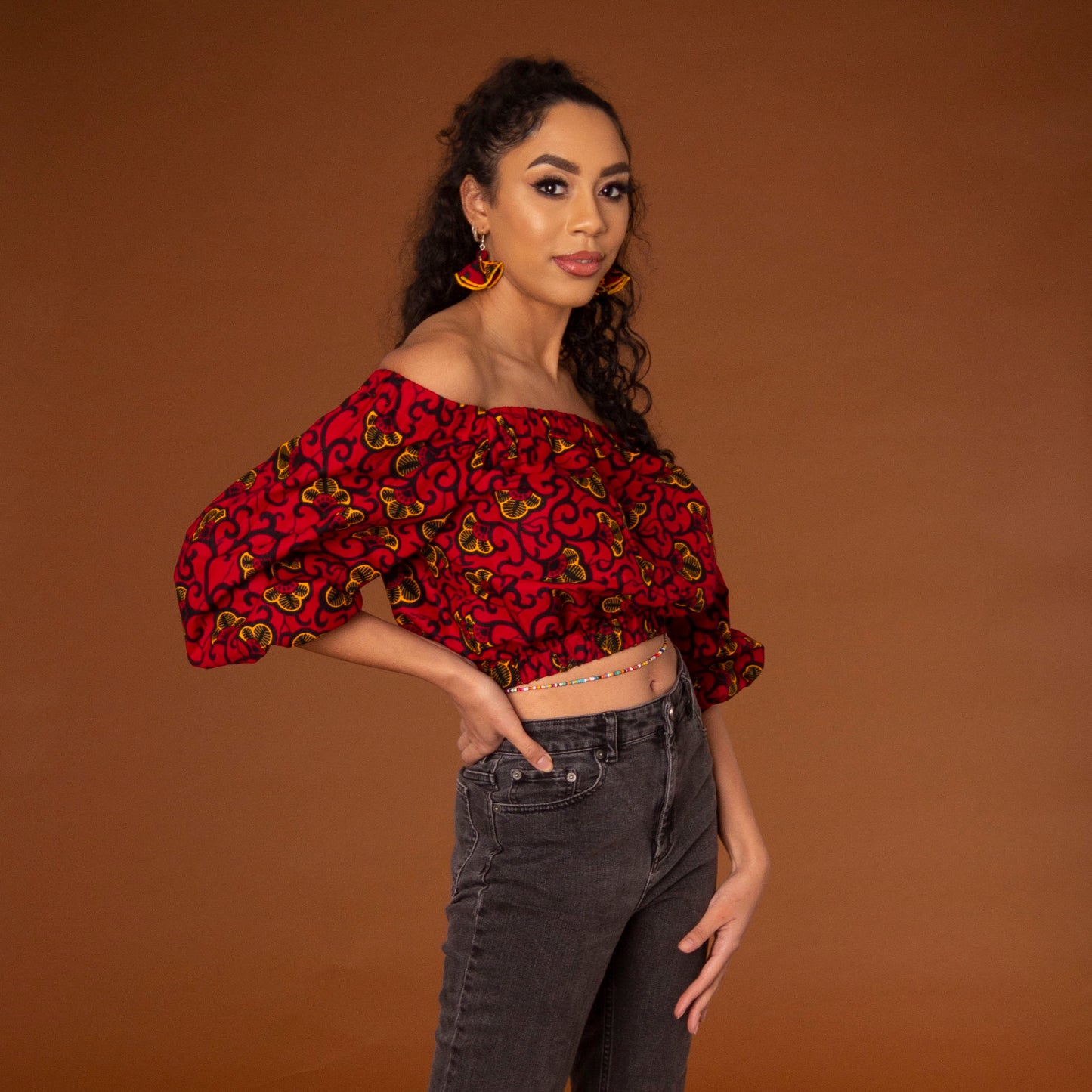 Off-shoulder African print crop top with three-quarter balloon sleeves and elasticated waist, arms and neckline in red and yellow ankara wax print