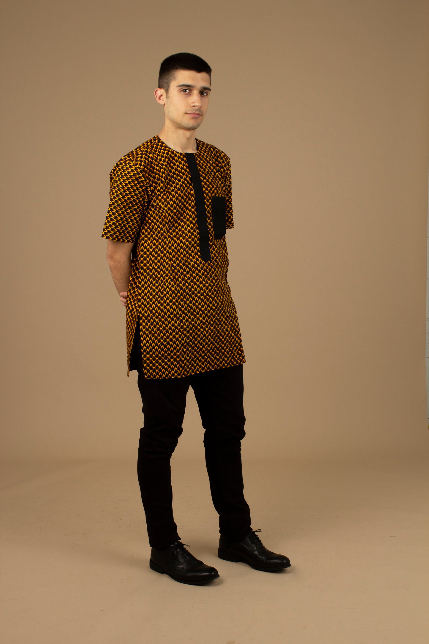 Vero African Print Kaftan Top is an ethically printed Matte Black Trimmed, Wax printed body style men's Kaftan top made from sustainably selected Cotton Ankara wax print in a repeated geometric brown and yellow African print pattern. Designed in England Made in Nigeria.