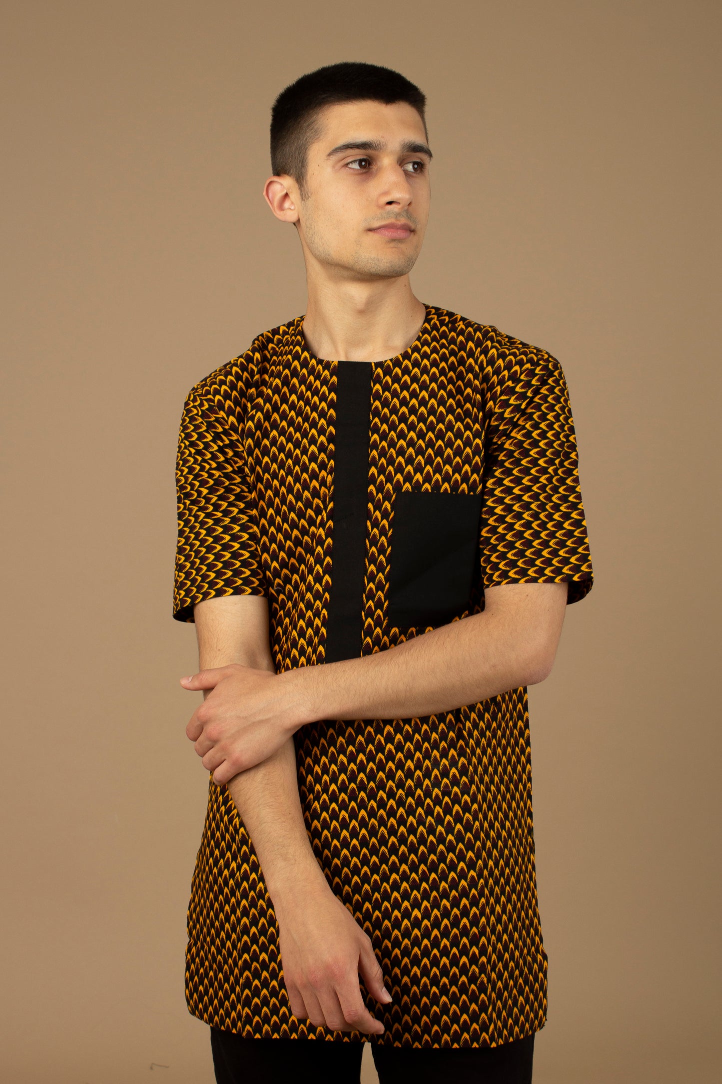 Vero African Print Kaftan Top is an ethically printed Matte Black Trimmed, Wax printed body style men's Kaftan top made from sustainably selected Cotton Ankara wax print in a repeated geometric brown and yellow African print pattern. Designed in England Made in Nigeria.