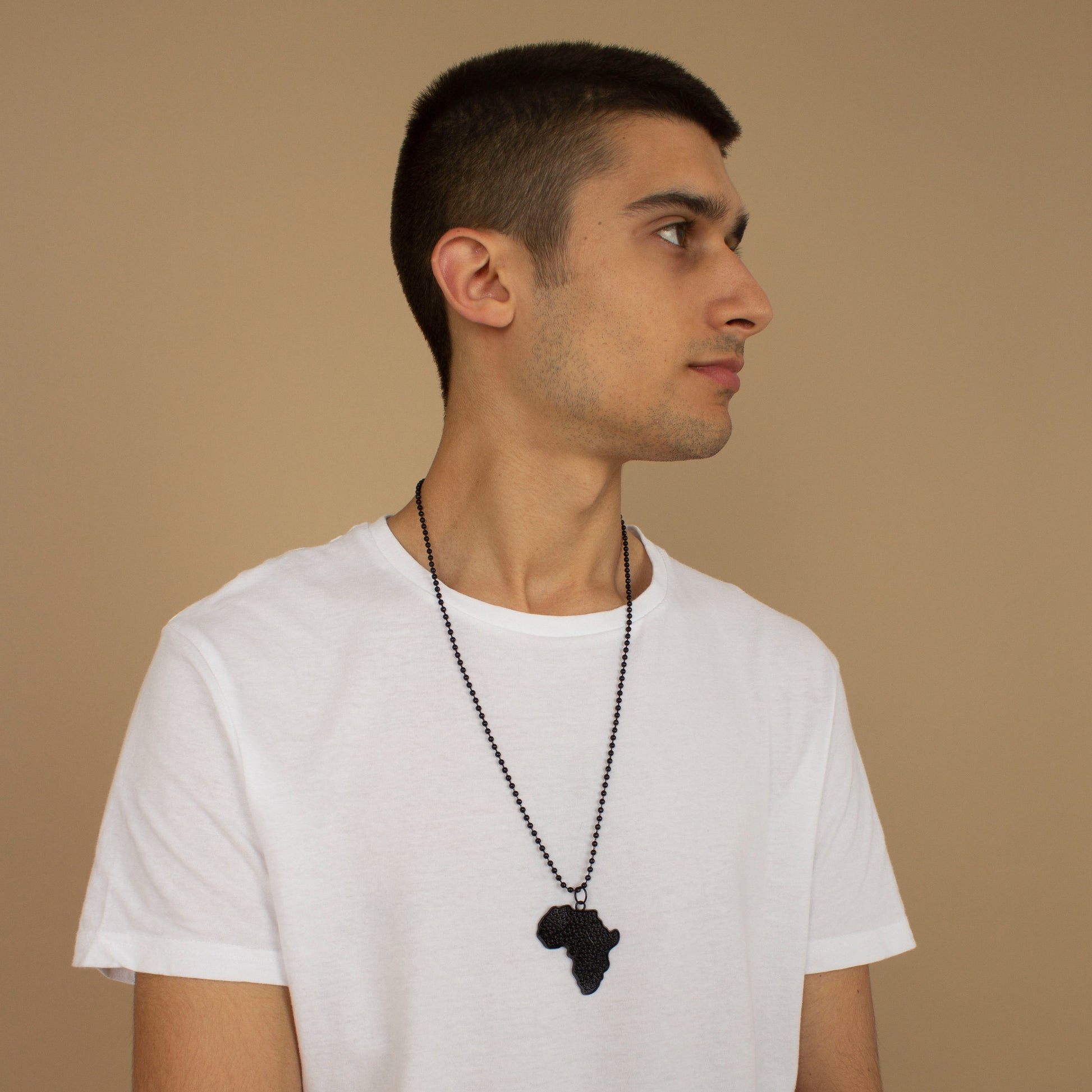 Unisex necklace with a African Map pendant featuring black metallic textured detailing and a metallic chain link. Available in one-size, Designed in England Made in Nigeria.