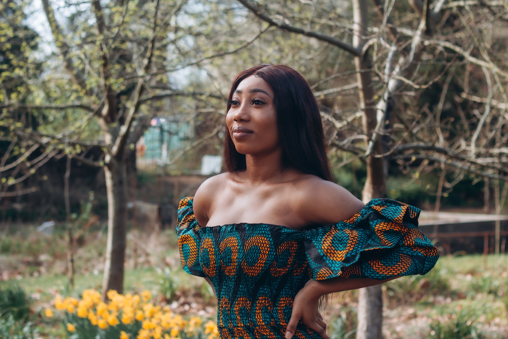 Adetayo African Ankara wax printed fabric in a green, orange and black circle geo-shaped pattern featured Midi-length dress, off-shoulder puff sleeve wit fitted bodice with a fitted elasticated waist reverse and closed back.