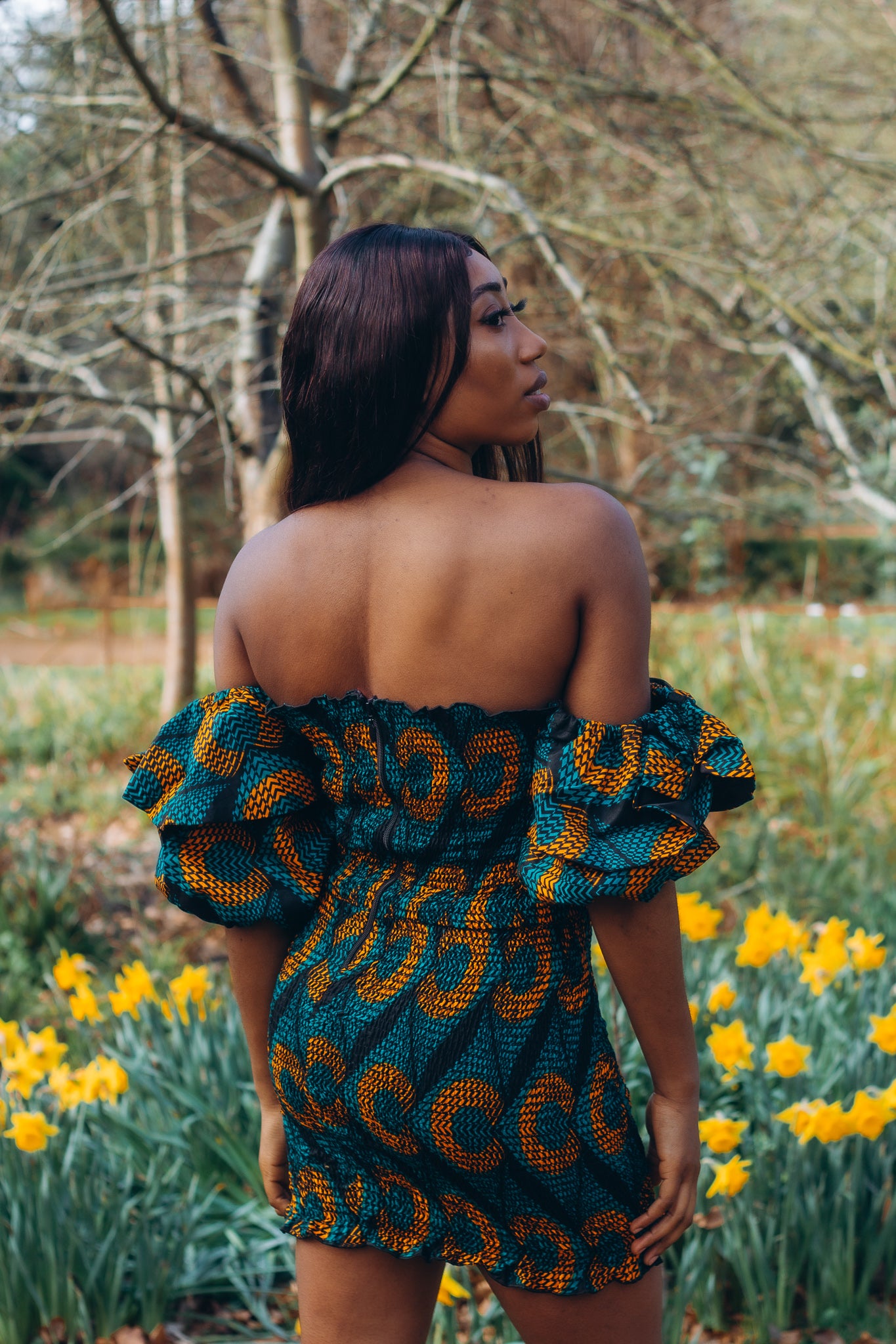 Adetayo African Ankara wax printed fabric in a green, orange and black circle geo-shaped pattern featured Midi-length dress, off-shoulder puff sleeve wit fitted bodice with a fitted elasticated waist reverse and closed back.