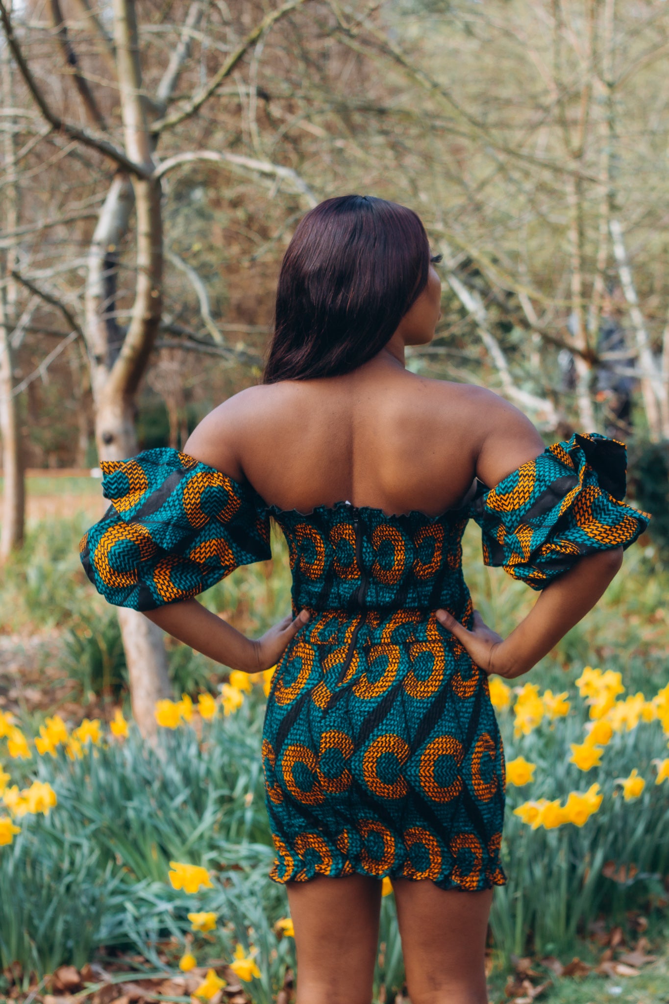 Adetayo African Ankara wax printed fabric in a green, orange and black circle geo-shaped pattern featured Midi-length dress, off-shoulder puff sleeve wit fitted bodice with a fitted elasticated waist reverse and closed back.