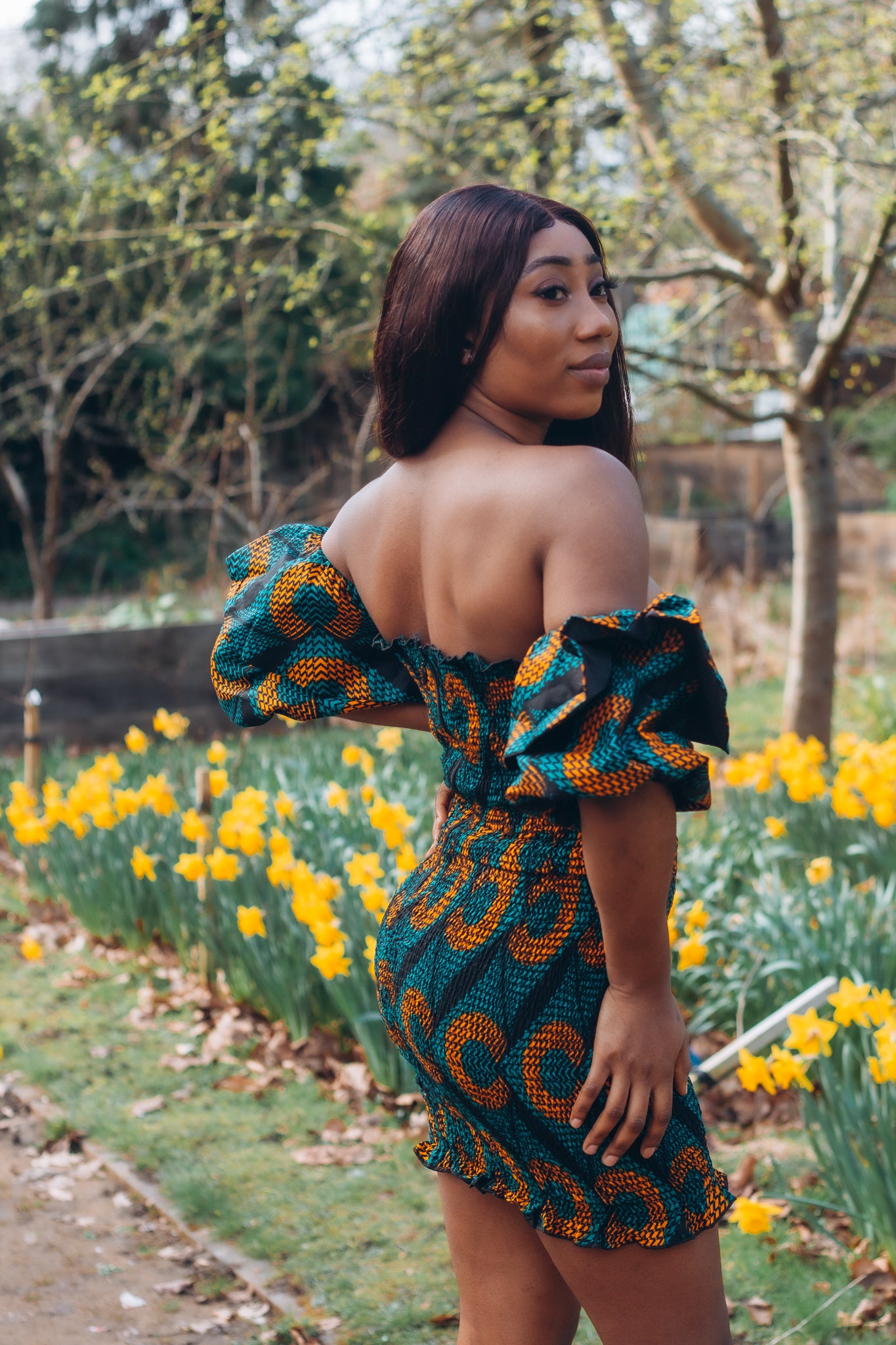 Adetayo African Ankara wax printed fabric in a green, orange and black circle geo-shaped pattern featured Midi-length dress, off-shoulder puff sleeve wit fitted bodice with a fitted elasticated waist reverse and closed back.