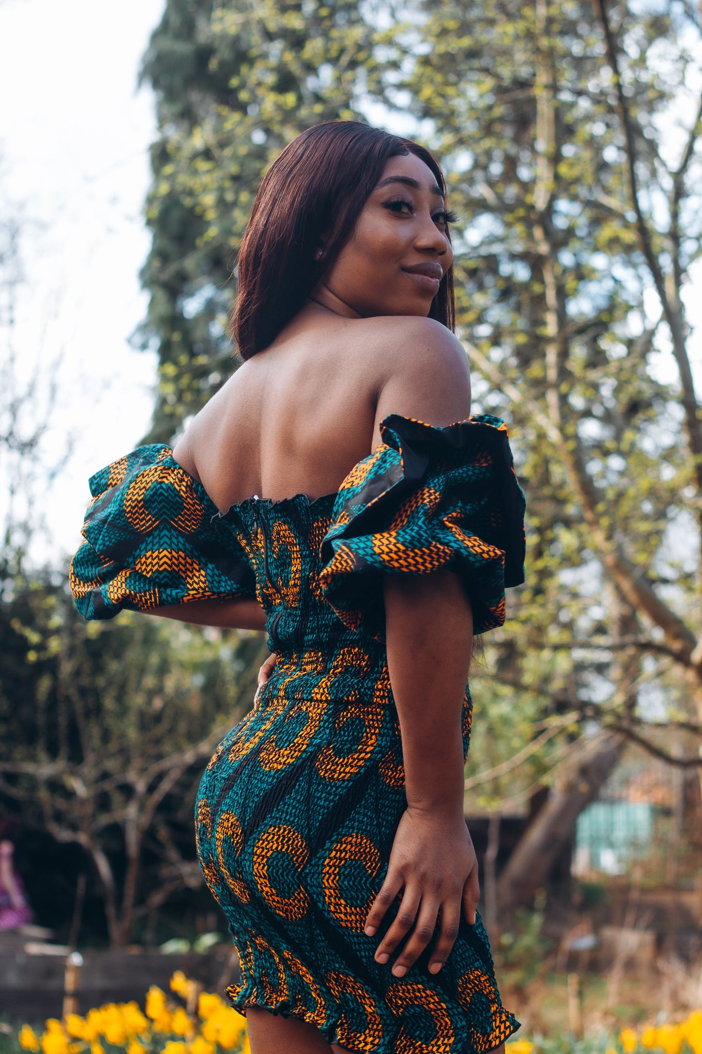 Adetayo African Ankara wax printed fabric in a green, orange and black circle geo-shaped pattern featured Midi-length dress, off-shoulder puff sleeve wit fitted bodice with a fitted elasticated waist reverse and closed back.